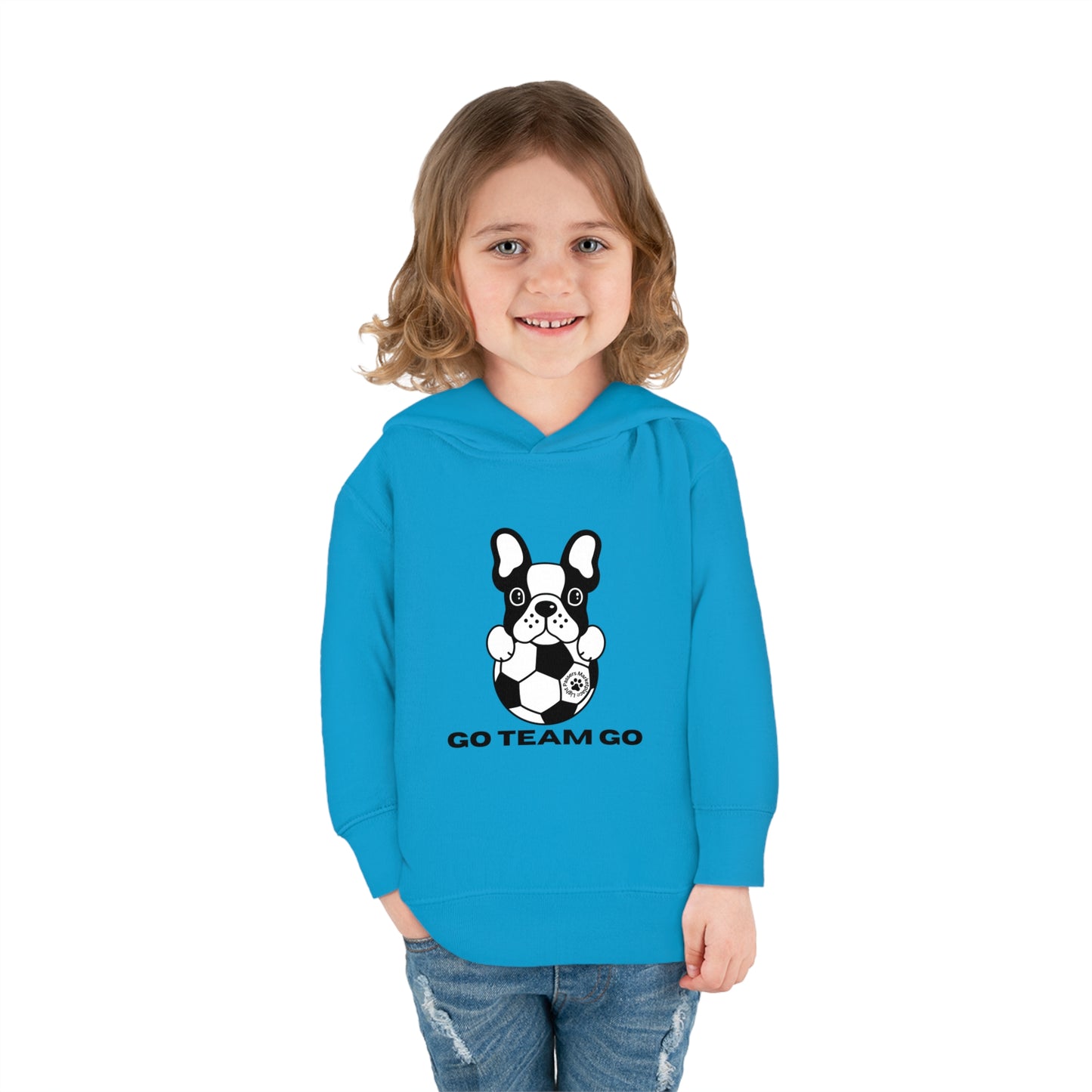 A child in a blue dog-themed toddler hoodie smiles, with a black and white dog holding a football in the background. Features jersey-lined hood, cover-stitched details, and side seam pockets for comfort and durability.