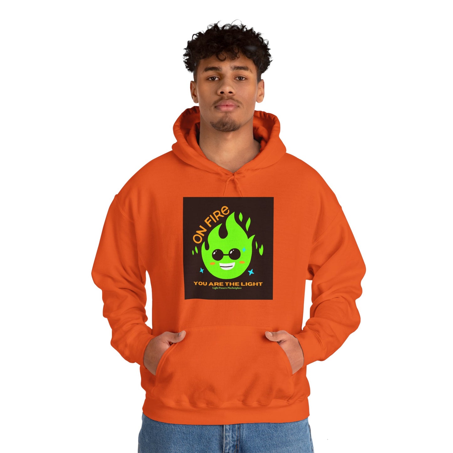 A man in an orange hooded sweatshirt with a green flame design, featuring a kangaroo pocket and color-matched drawstring. Made of 50% cotton and 50% polyester for warmth and comfort.
