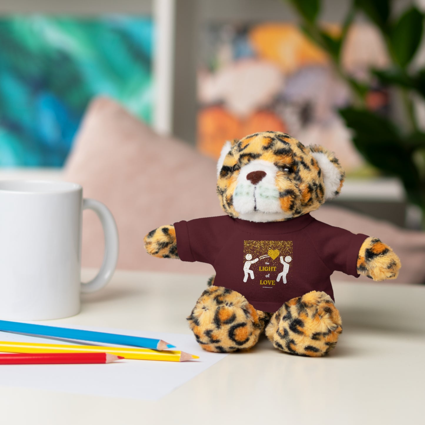 Cool Stuff Stuffies Light of Love Gold Heart stuffed animal, 8 inches tall, wearing a customizable 100% cotton tee, sitting on a table.