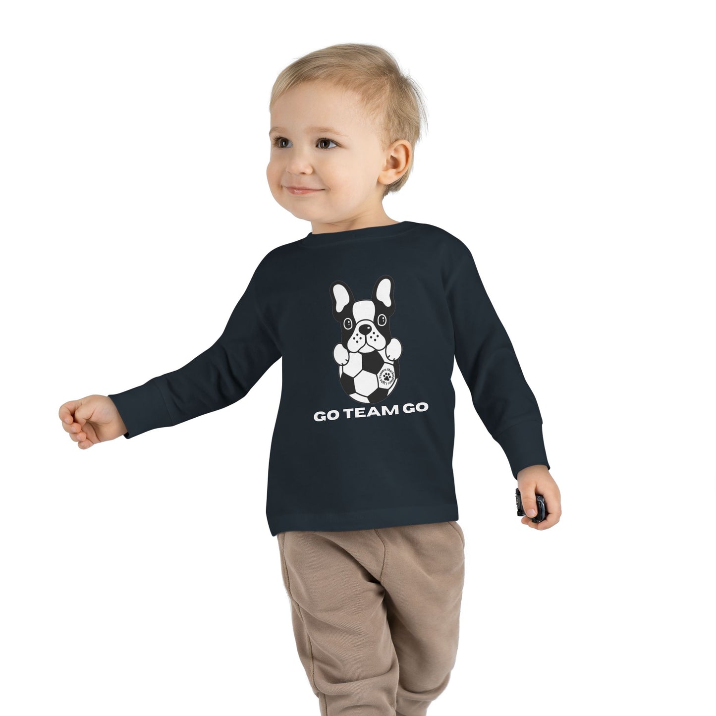 Soccer Dog Toddler Long Sleeve: Toddler wearing long-sleeved tee with dog and soccer ball design, ideal for young sports fans. Comfortable and perfect for casual or game days.
