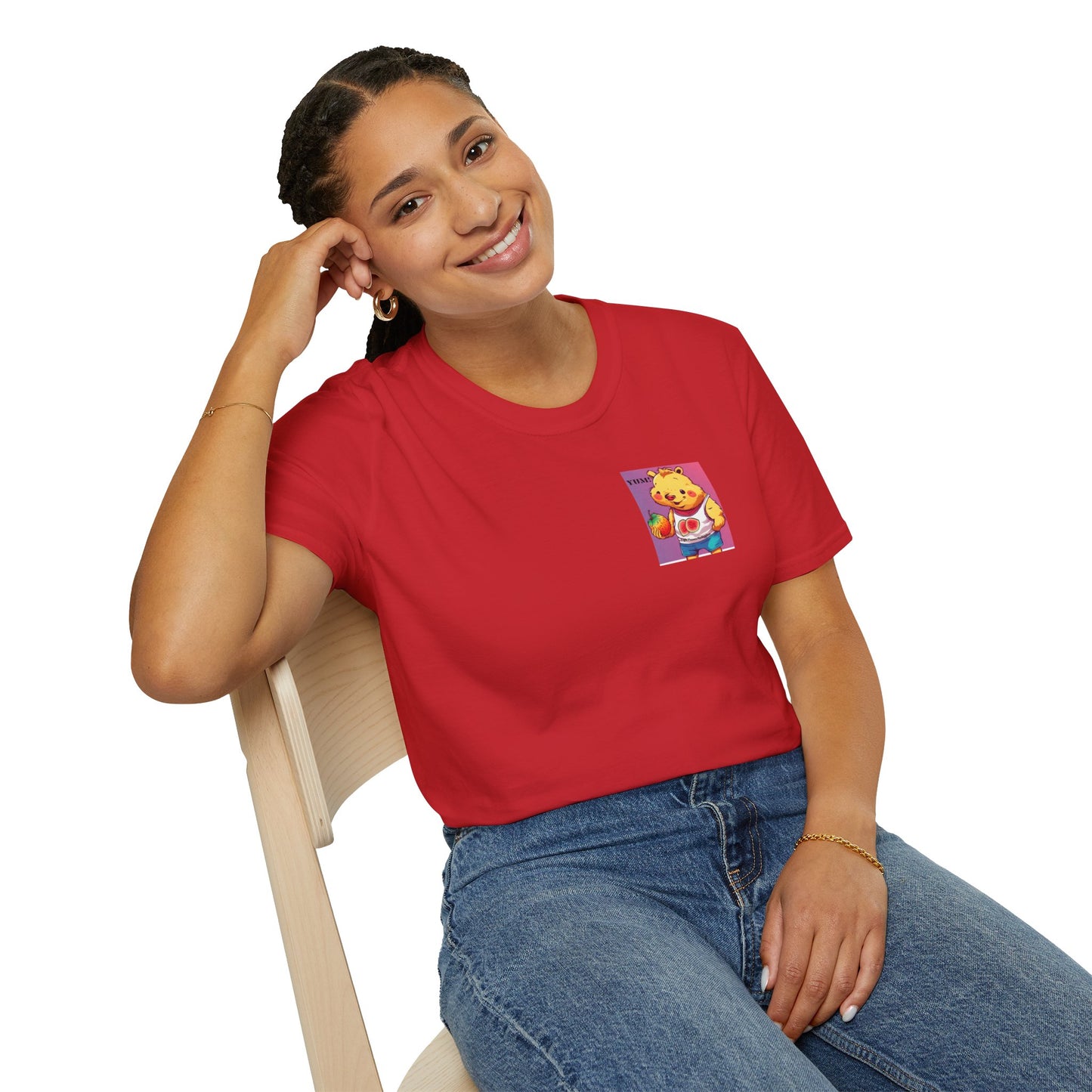 A woman in a red shirt sits on a chair, showcasing the Yum Strawberries Unisex T-Shirt. The tee, made of soft 100% cotton, features twill tape shoulders and a ribbed collar for durability and comfort.