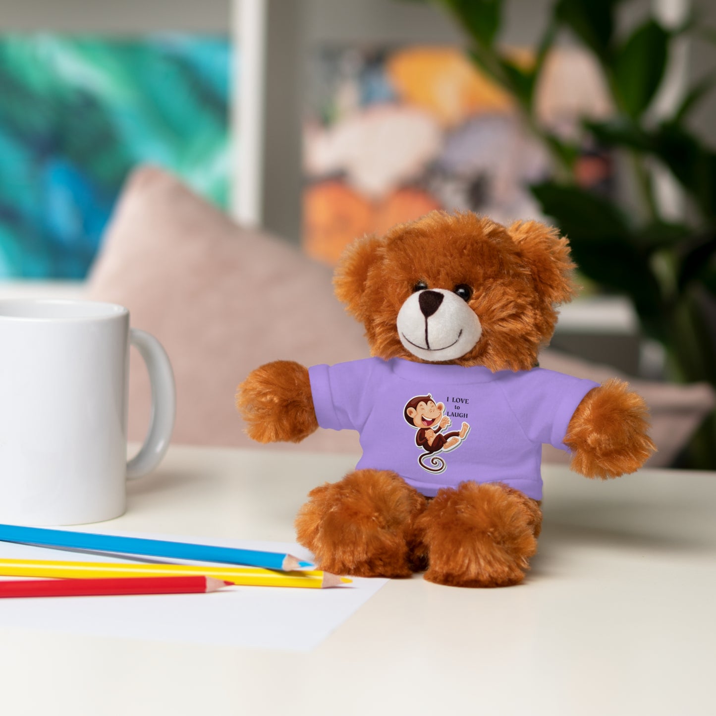 Cool Stuff Stuffies 6 Animals I Love to Laugh Monkey plush toy with a removable T-shirt, shown on a table beside a white mug.