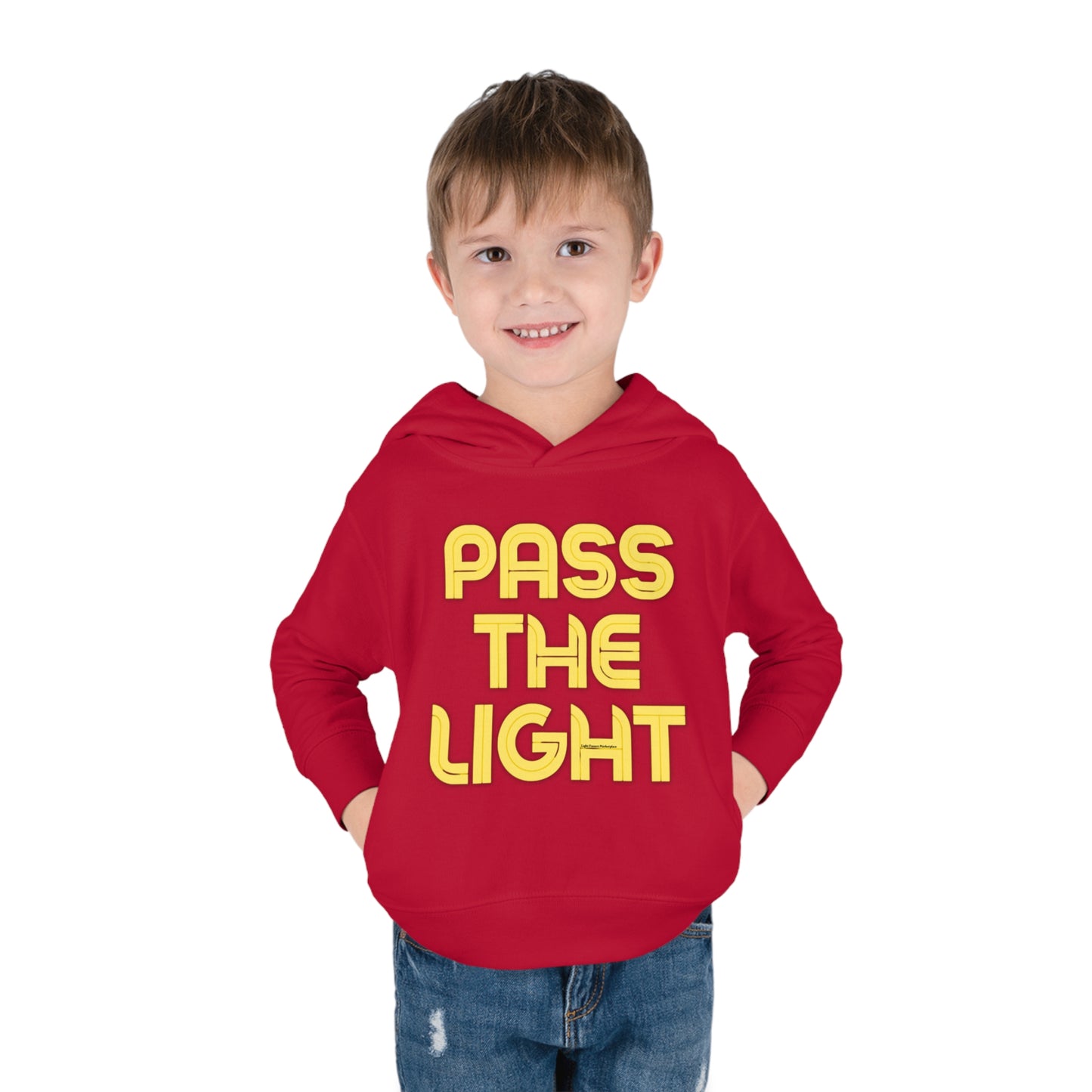 A boy in a Pass the Light Toddler Hooded Sweatshirt with yellow text, featuring side-seam pockets and cover-stitched details for durability and comfort.