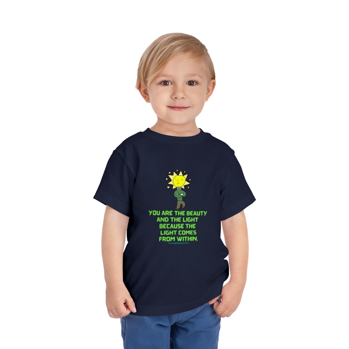 A young boy in a blue shirt, showcasing the Beauty and the Light Toddler T-shirt. Made of 100% Airlume combed cotton, tear-away label for comfort.