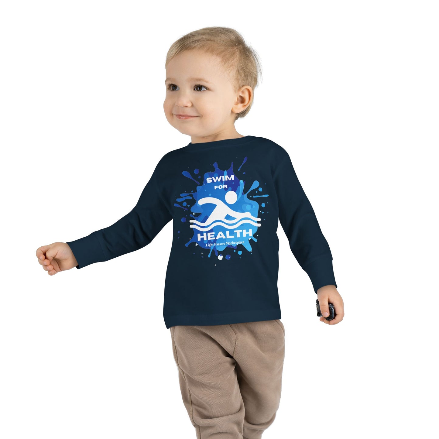 Toddler wearing a Swim for Health Long Sleeve Tee, walking towards the camera, showcasing the shirt's structure and ribbed collar, ideal for pool or beach activities.