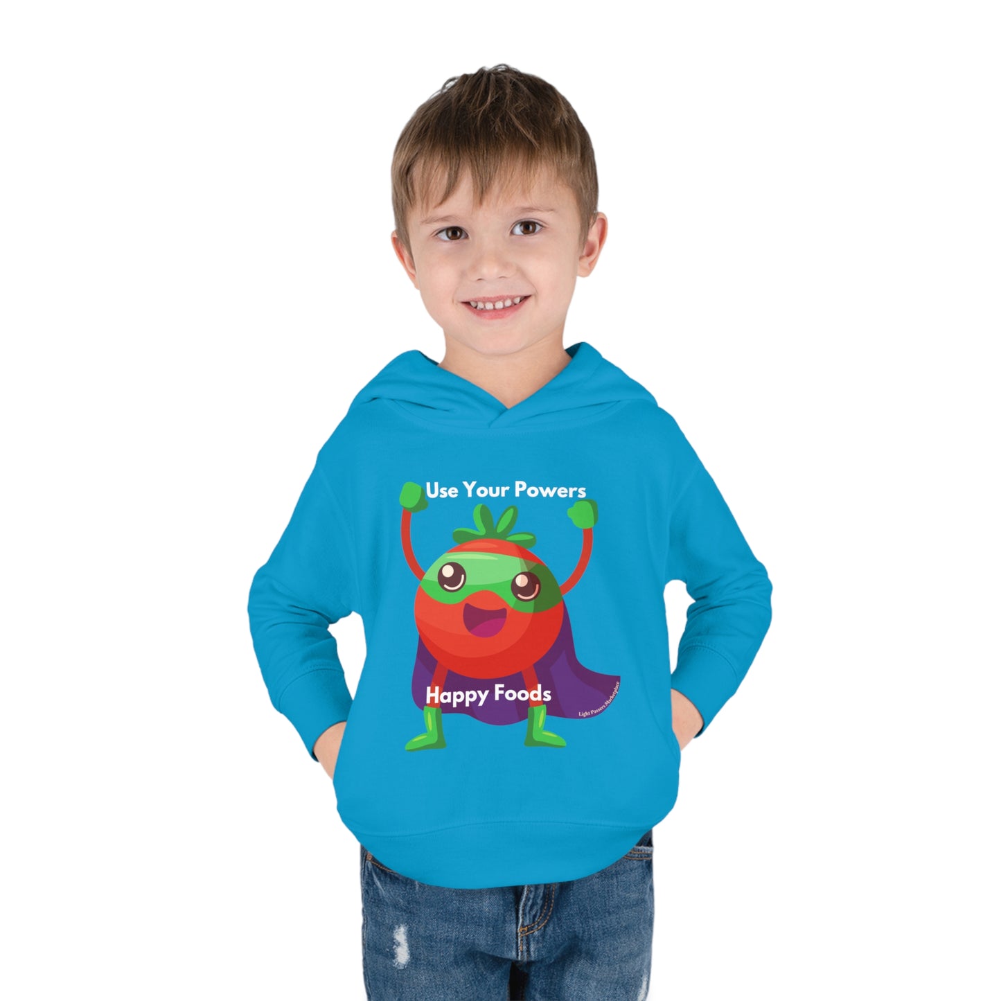 A smiling boy in a blue Rabbit Skins Tomato Power Toddler Hoodie with side seam pockets. Features jersey-lined hood, cover-stitched details, and durable cotton-polyester blend for cozy wear.