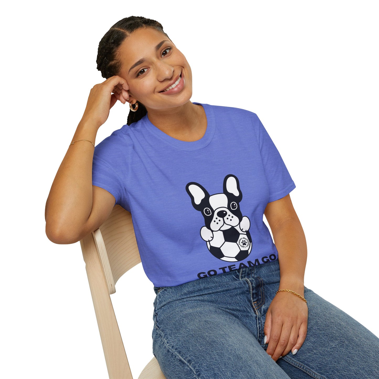 A woman sits in a blue shirt with a dog graphic, showcasing a Soccer Dog Unisex T-Shirt. Soft 100% cotton tee with twill tape shoulders, ribbed collar, and tear-away label for ultimate comfort and style.