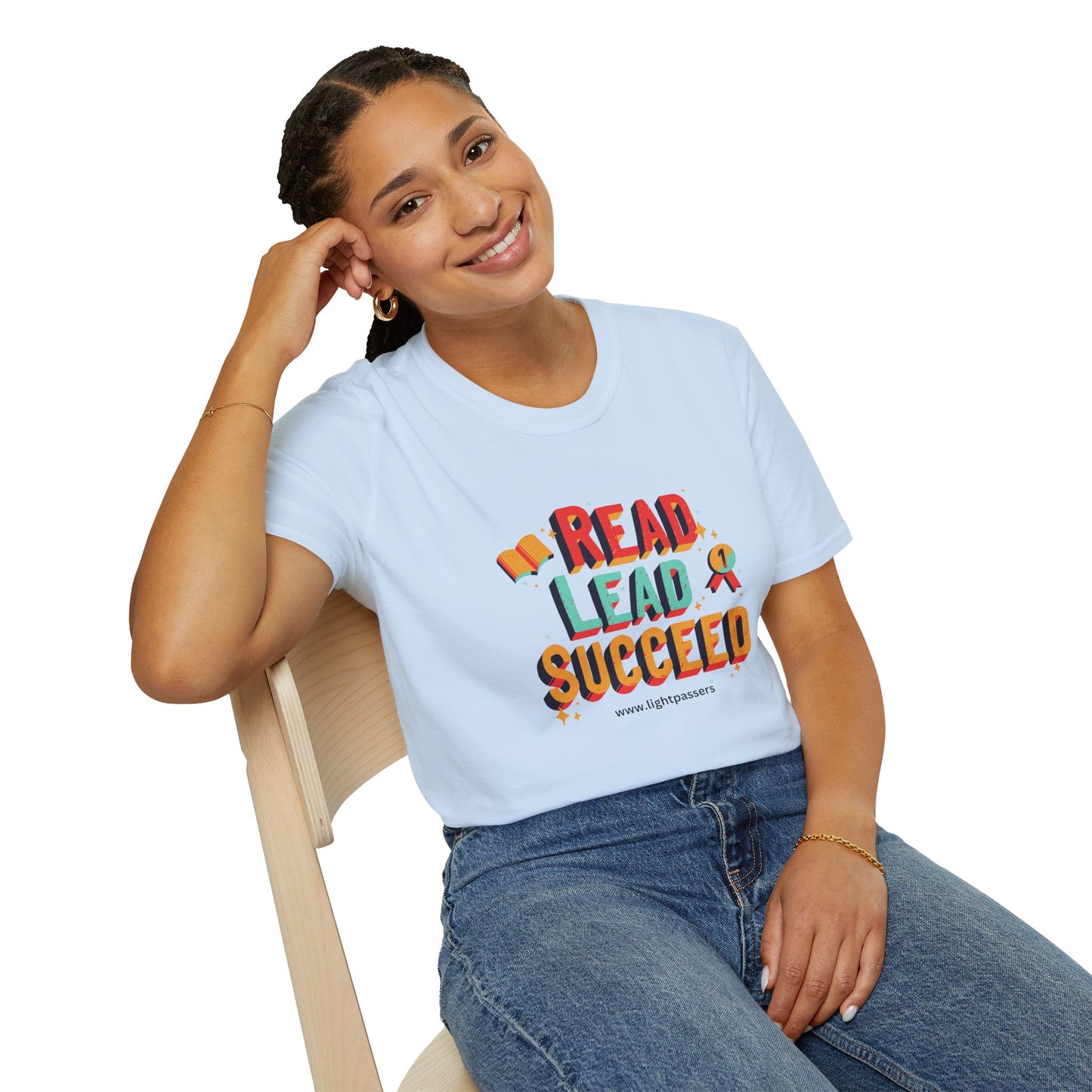 A smiling woman in a white shirt sits on a chair, showcasing the Read Lead Succeed Unisex T-Shirt. Close-up of the soft fabric and durable twill tape shoulders.