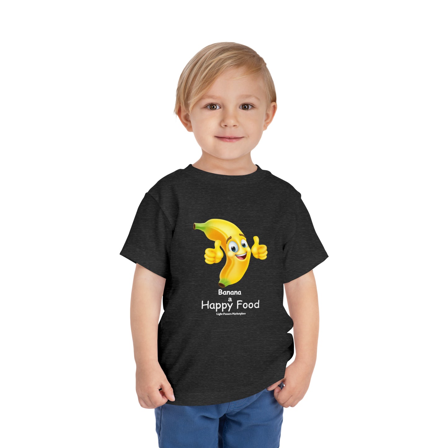 A toddler in a black t-shirt smiles, paired with a cartoon banana giving a thumbs up. Bella Canvas tee, 100% Airlume cotton, tear-away label.