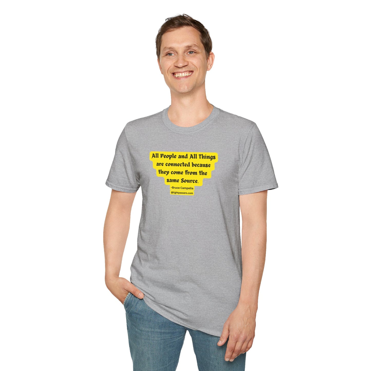 A man in a grey shirt with yellow text, smiling, hands in pockets. Unisex heavy cotton tee, smooth surface for vivid printing, no side seams, tape on shoulders for durability.