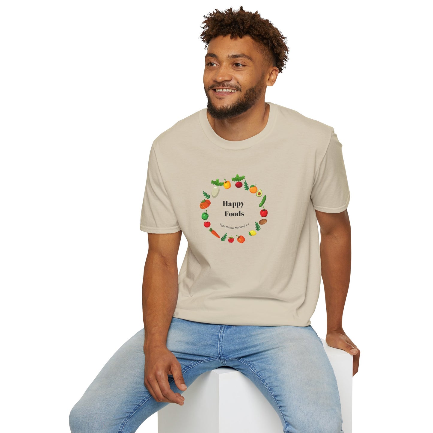 A man in a Happy Foods Ring Unisex T-Shirt, sitting on a white cube. The tee, made of soft 100% cotton, features a crew neckline and twill tape shoulders for durability. Ethically produced with Oeko-Tex certification.
