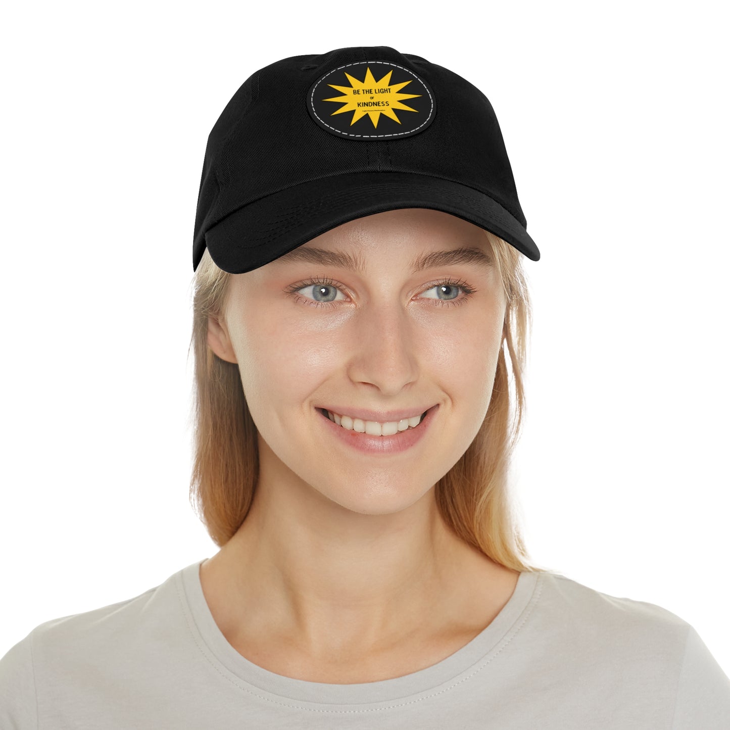 Unisex hat featuring 'Be the Light of Kindness' on a PU leather patch, worn by a woman, highlighting its stylish design and positive message.