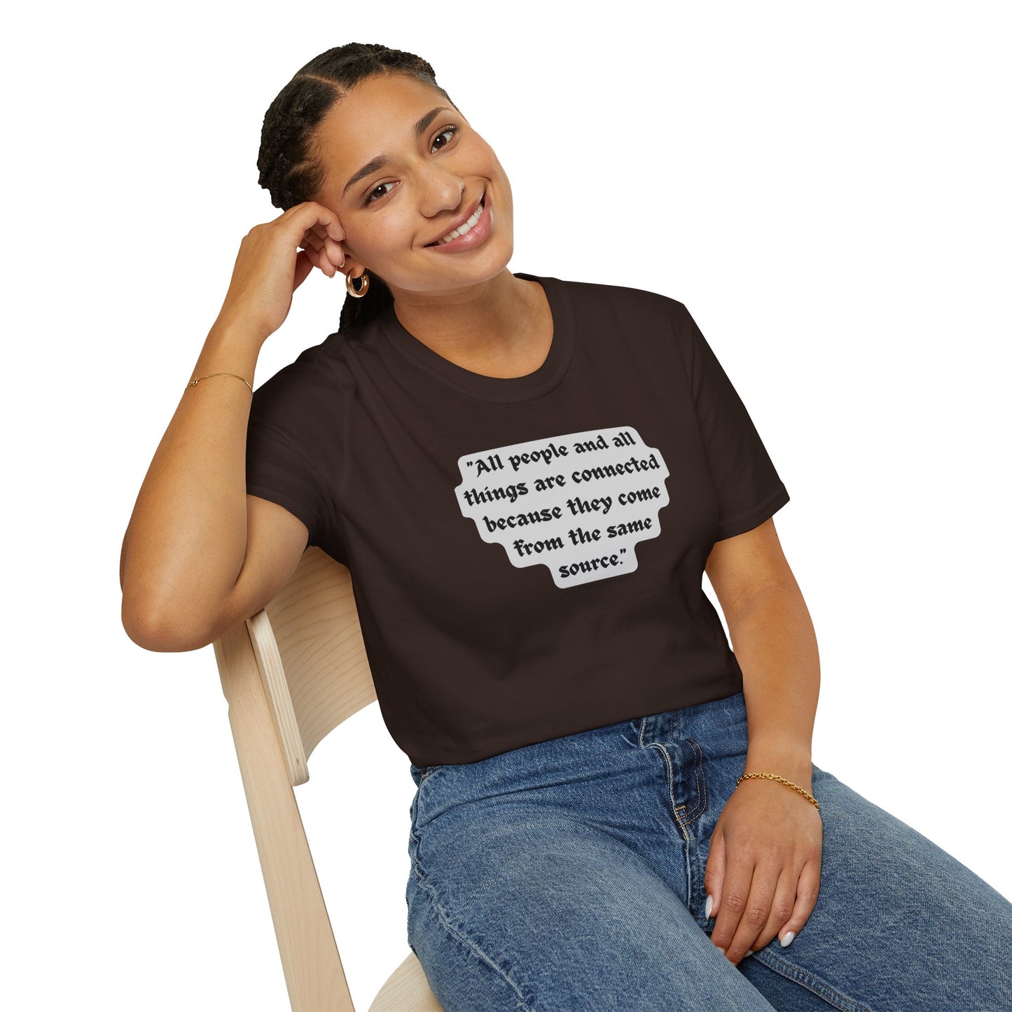 A woman in a brown shirt smiles, sitting on a chair, showcasing the All People are Connected Gray Unisex T-shirt. Product features include 100% cotton, tear-away label, and a classic fit.