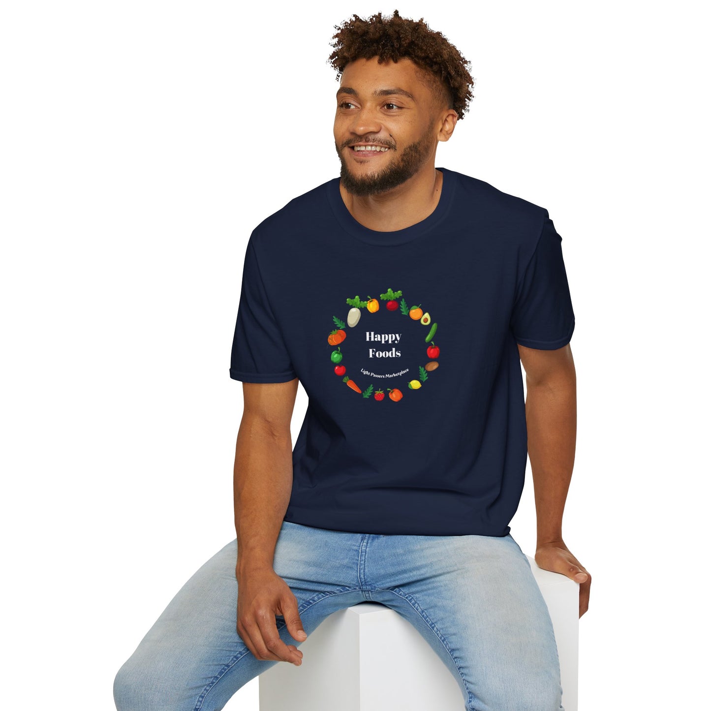 A man in a blue shirt with a logo sits on a white cube, showcasing the Happy Foods Ring Unisex T-Shirt. Made of soft 100% cotton, featuring twill tape shoulders for durability and a clean crew neckline.