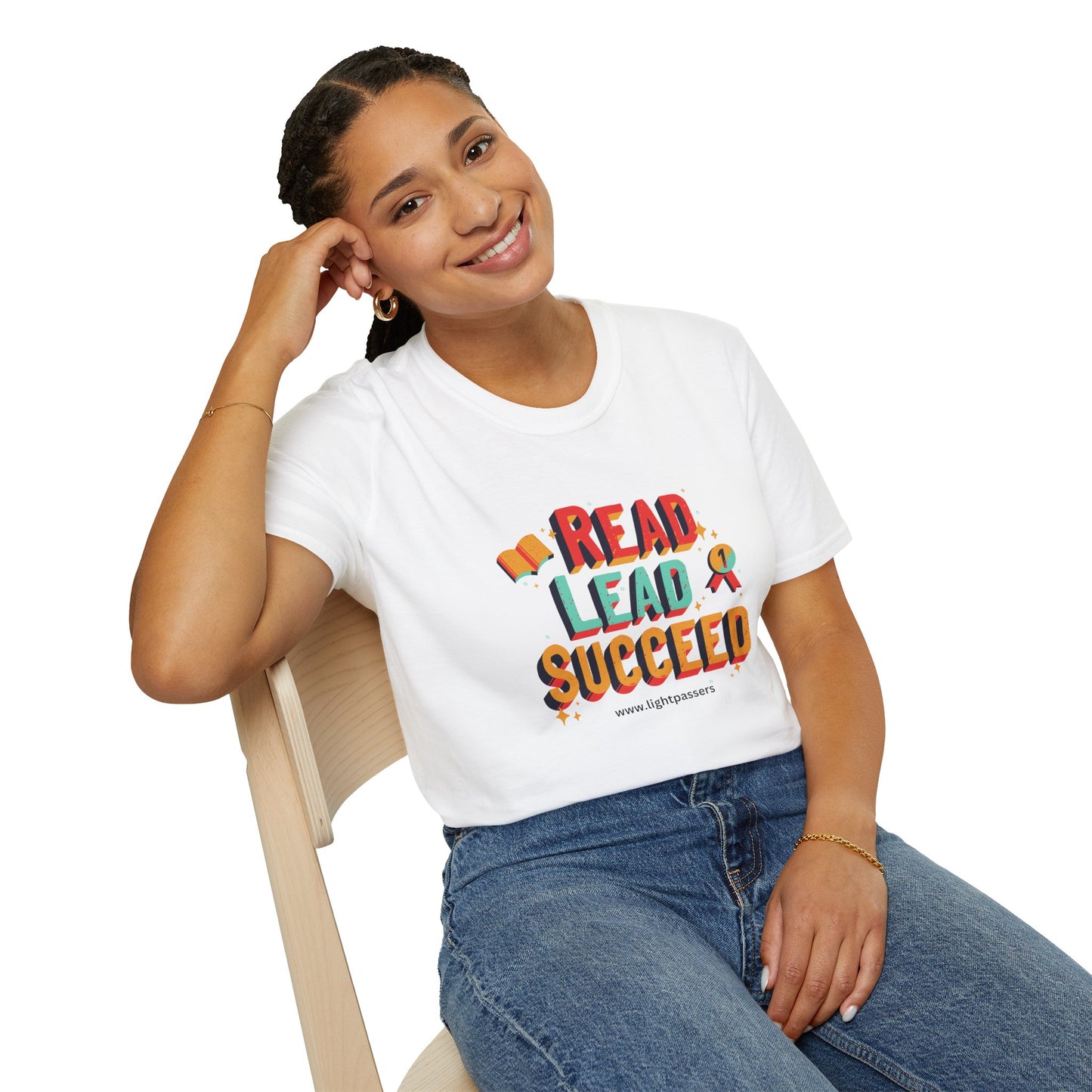 A woman in a white shirt sits on a chair, showcasing the Read Lead Succeed Unisex T-Shirt. Soft 100% cotton tee with twill tape shoulders, no side seams, and ribbed collar.