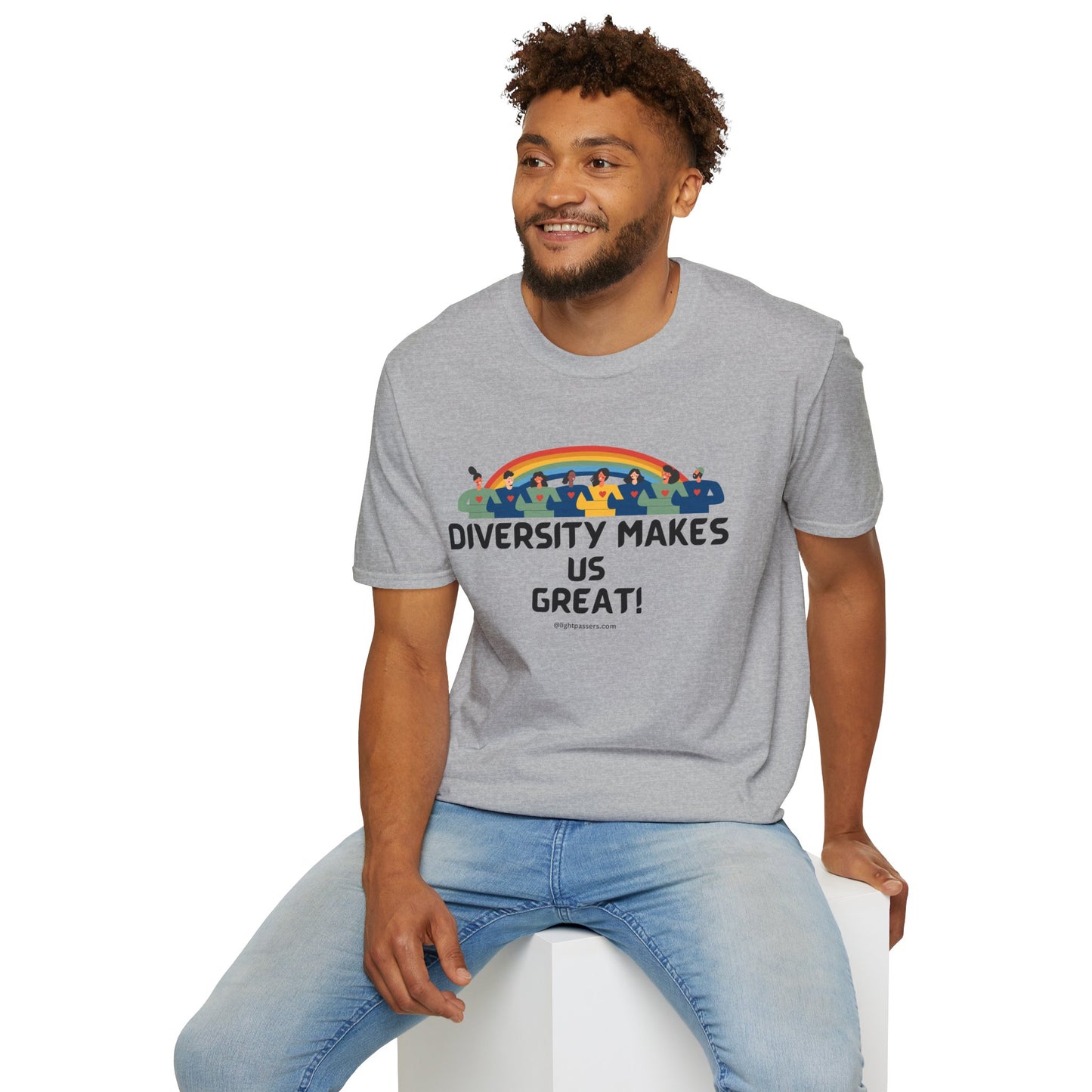 A man in a grey shirt sits on a cube, showcasing the Diversity Makes Us Great yellow text Unisex T-shirt. The tee boasts 100% cotton, smooth surface for vivid printing, and tear-away label for comfort.