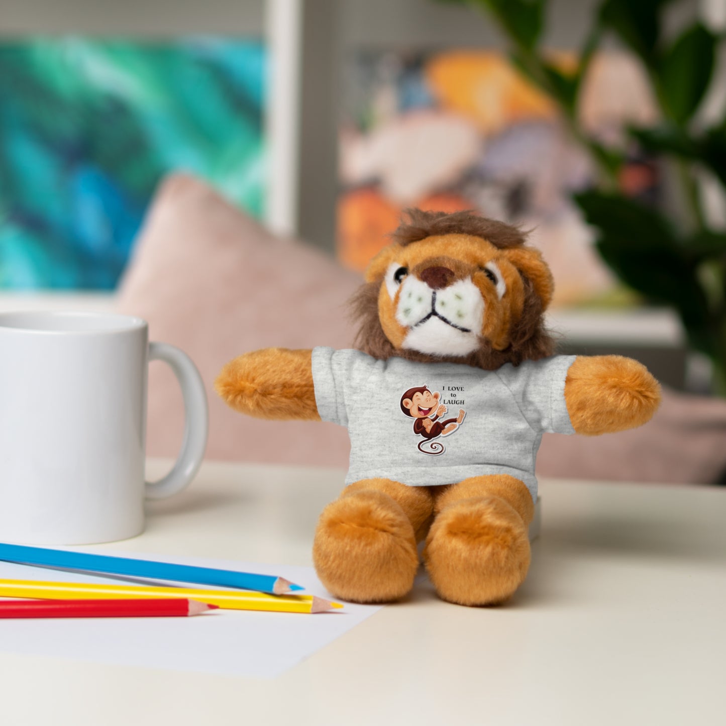 Cool Stuff Stuffies plush toy, a monkey with a removable I Love to Laugh T-shirt, sitting on a table. Perfect for kids' play and snuggles.