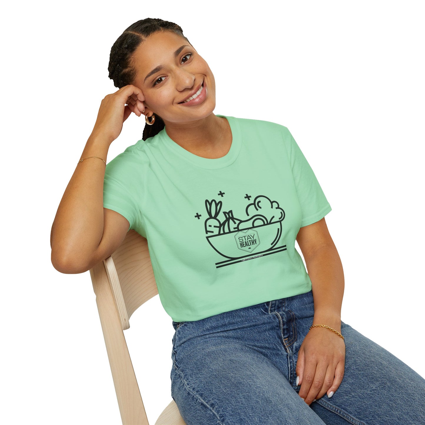 A woman in a green shirt sits on a chair, showcasing the Stay Healthy Unisex T-Shirt. Made of soft 100% cotton, featuring twill tape shoulders and a ribbed collar for durability and comfort.