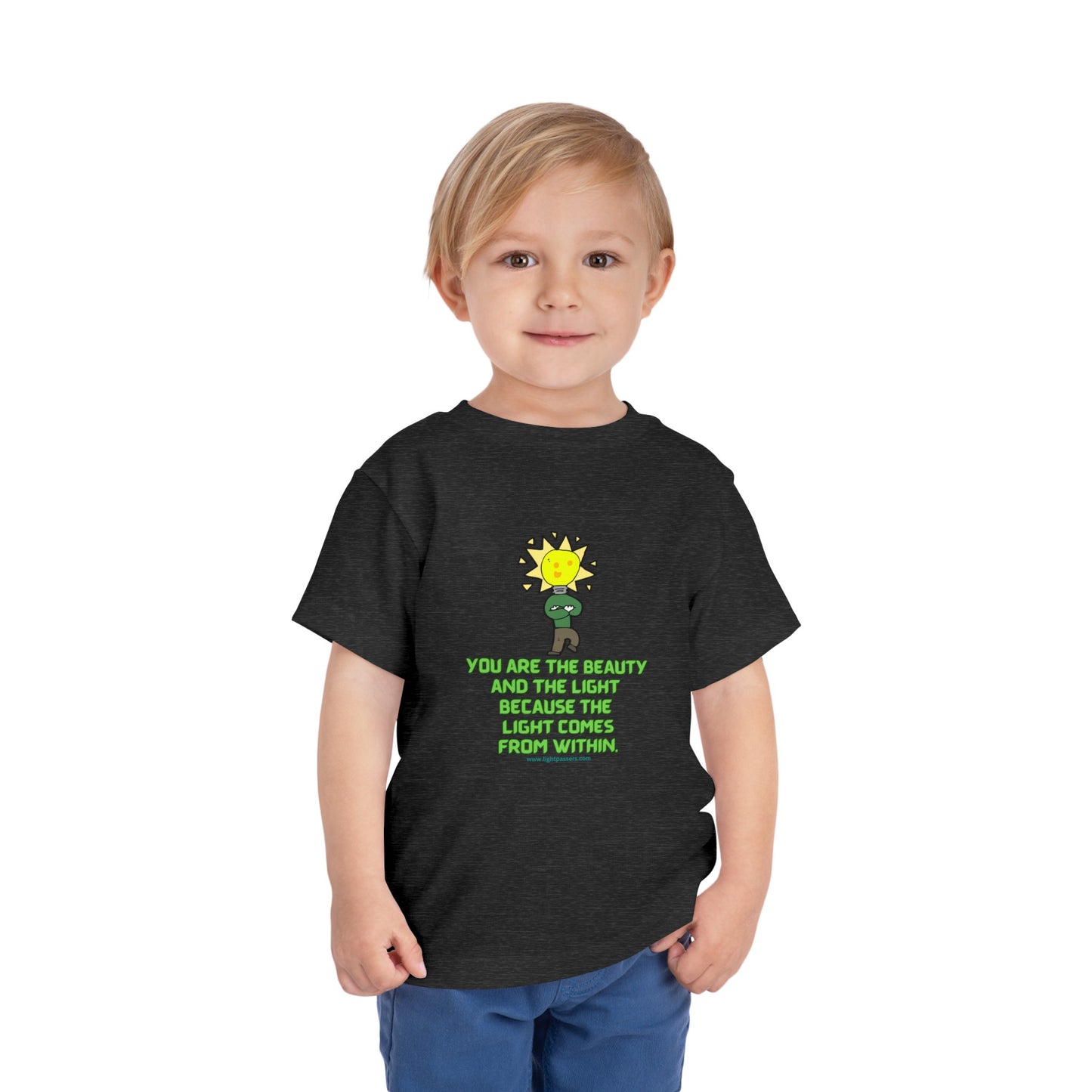 A toddler in a black shirt, close-up of face, wearing blue jeans. Bella Canvas tee, 100% cotton, tear-away label, light fabric. Beauty and the Light Toddler T-shirt.