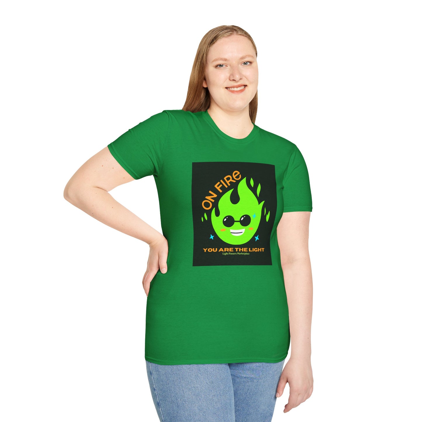 A woman in a green shirt with a green flame and yellow text, showcasing the On Fire You are the Light Unisex T-Shirt. Made of soft 100% cotton, featuring twill tape shoulders and a ribbed collar.