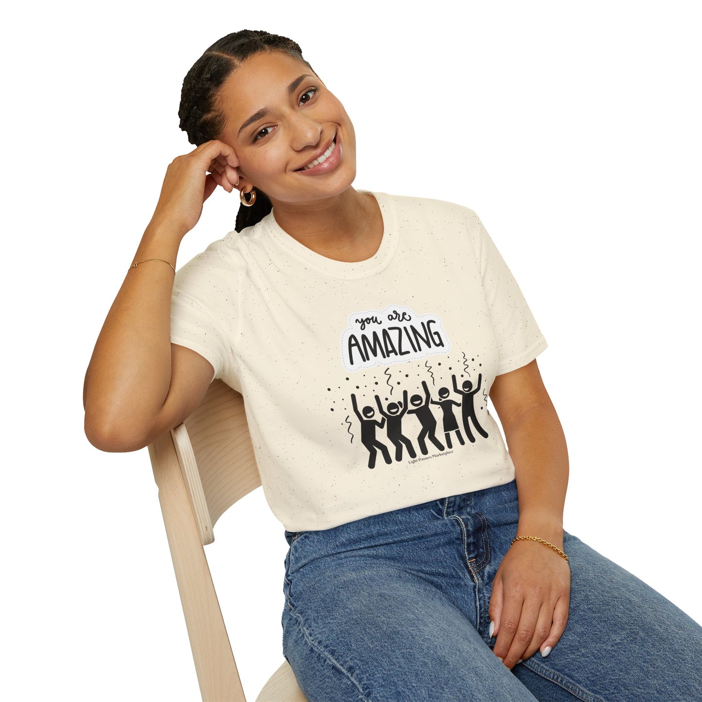 A woman in a white shirt, smiling, sits on a chair, showcasing the You are Amazing Group Unisex T-Shirt. The tee is 100% cotton, with twill tape shoulders for durability, and a clean crew neckline for versatile style.