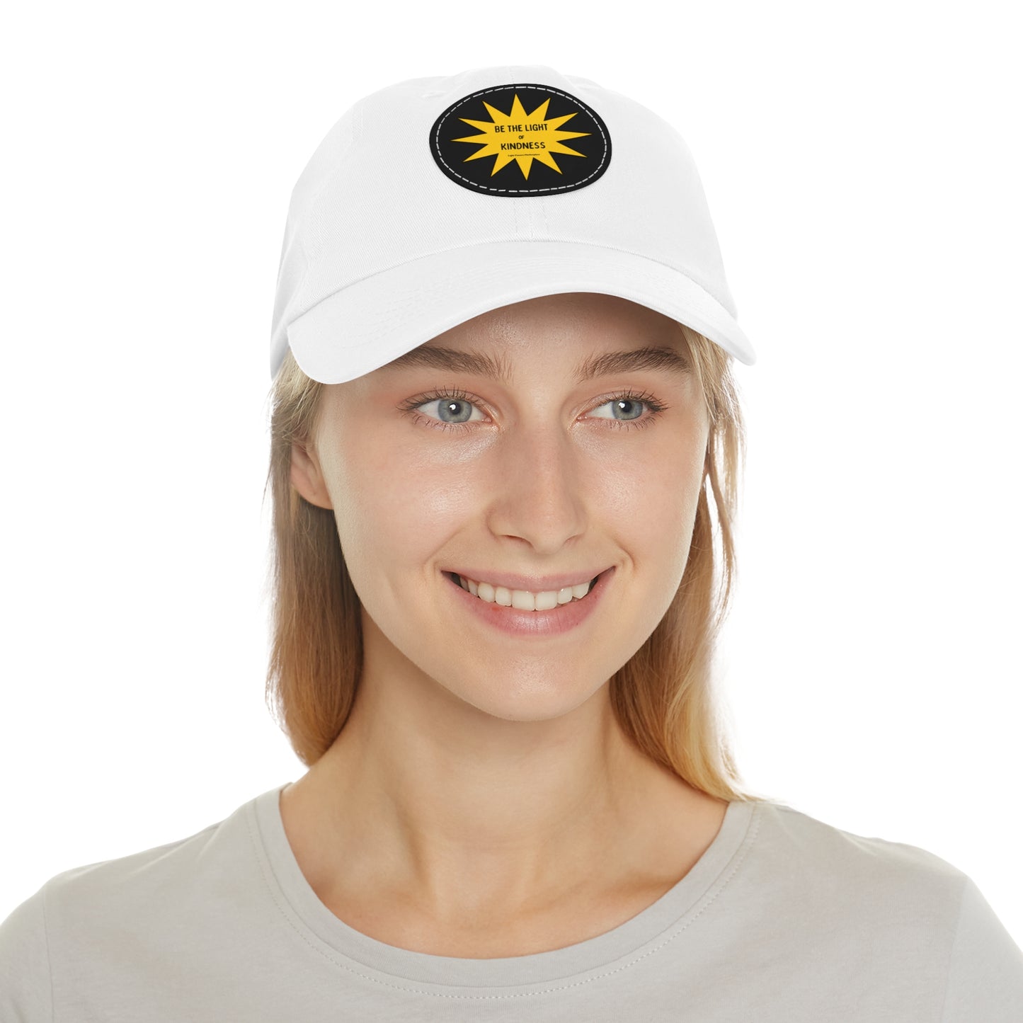 Unisex hat with 'Be the Light of Kindness' on a PU leather patch, worn by a woman; features a buckle closure and durable chino twill fabric.
