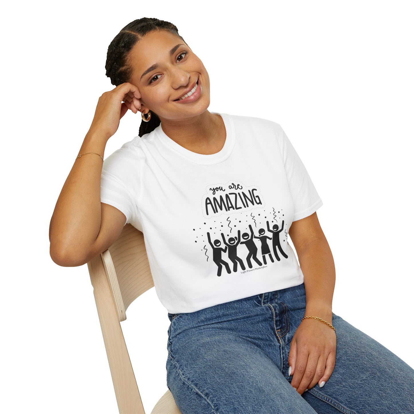 A woman in a white shirt and blue jeans smiles, sitting on a chair. Unisex soft-style t-shirt made of 100% ring-spun cotton, featuring twill tape shoulders and no side seams for enhanced durability and comfort.