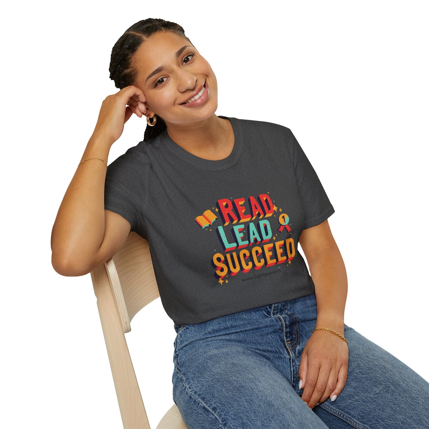 A woman in a grey shirt sits on a chair, smiling. A close-up of a woman's face. Product: Read Lead Succeed Unisex T-Shirt, emphasizing comfort with 100% cotton, twill tape shoulders, and tear-away label.