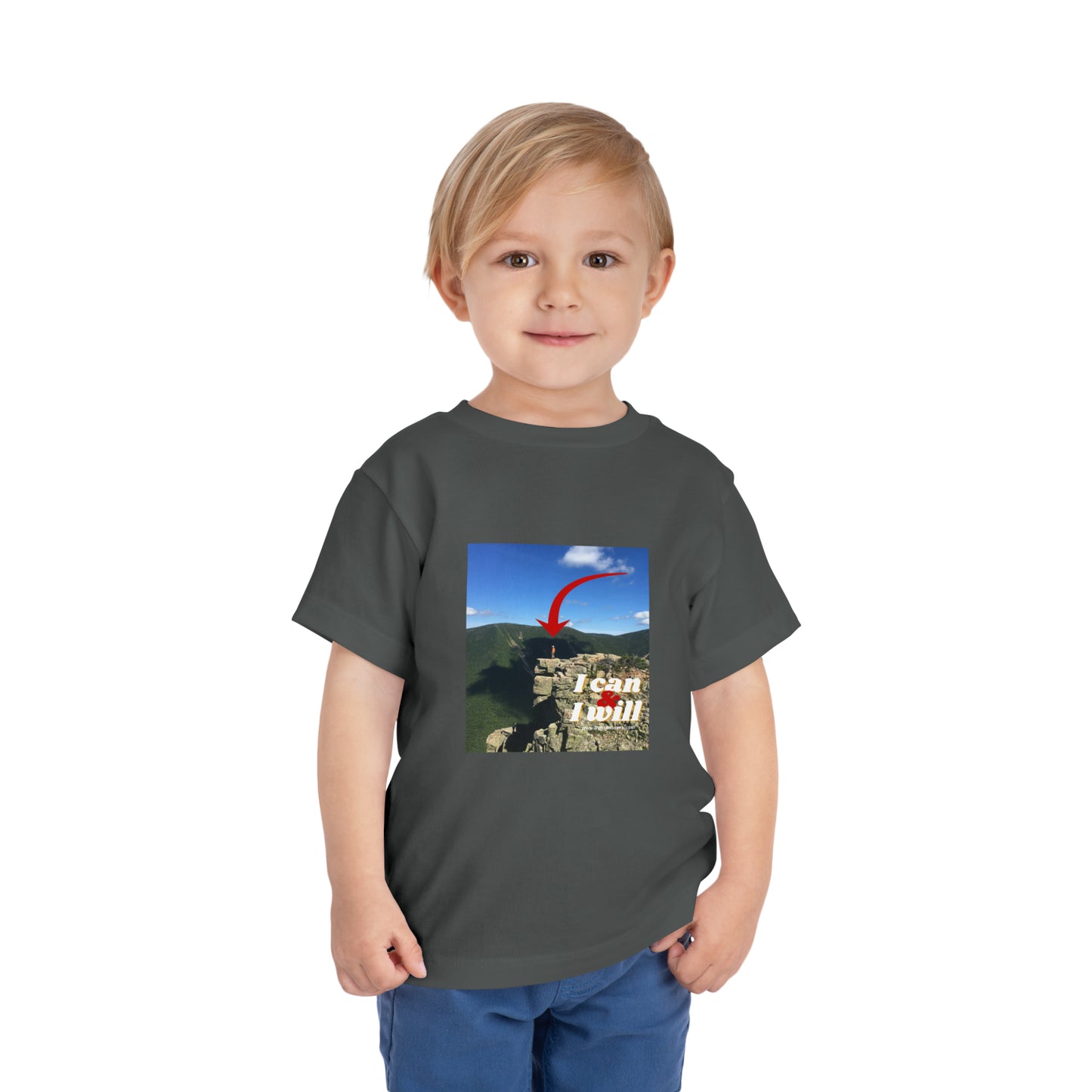 A determined toddler in a grey I Can and I Will hiking t-shirt, standing confidently. Made of 100% Airlume cotton, tear-away label for comfort.