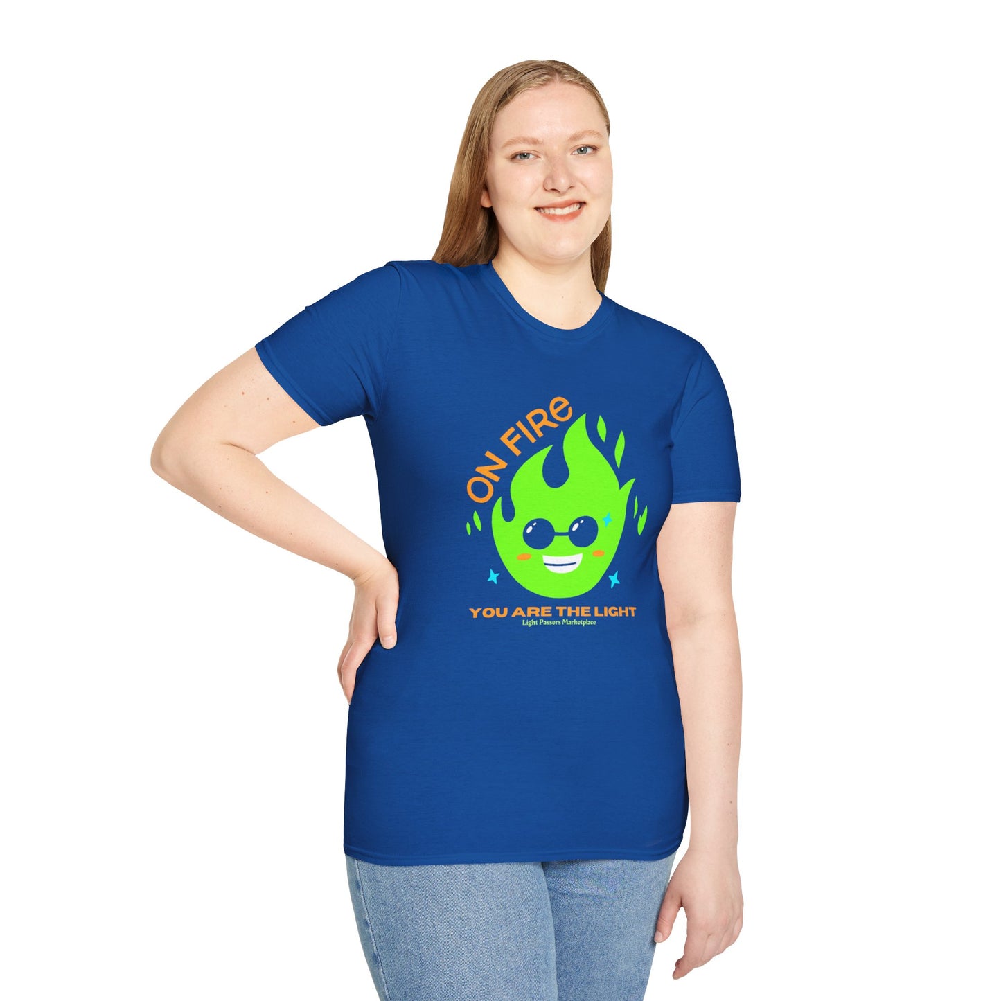 A woman in a blue shirt, smiling, showcases the On Fire You are the Light Unisex T-Shirt. Soft 100% cotton tee with twill tape shoulders, ribbed collar, and no side seams.