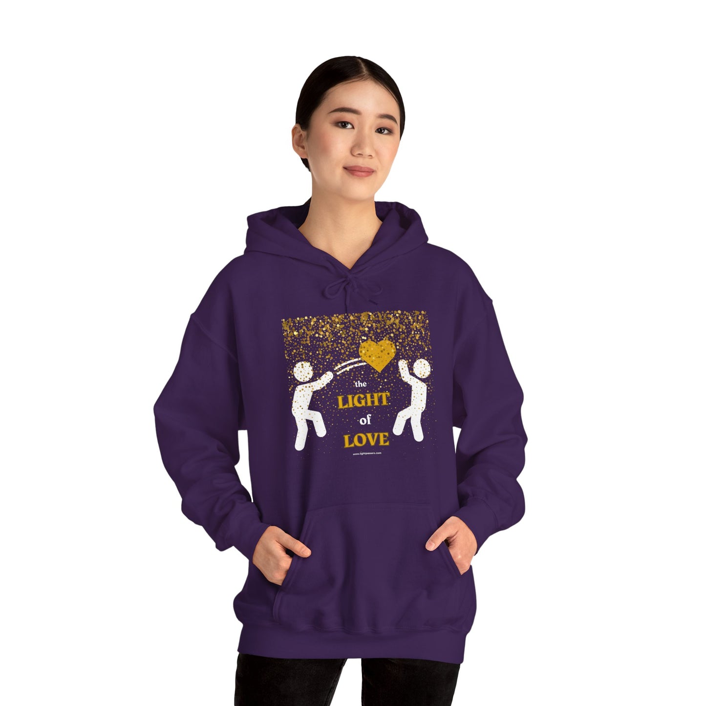 A person in a purple hoodie with a gold heart design, featuring a kangaroo pocket and color-matched drawstring. Made of 50% cotton and 50% polyester for warmth and comfort. Ethically produced by Gildan.