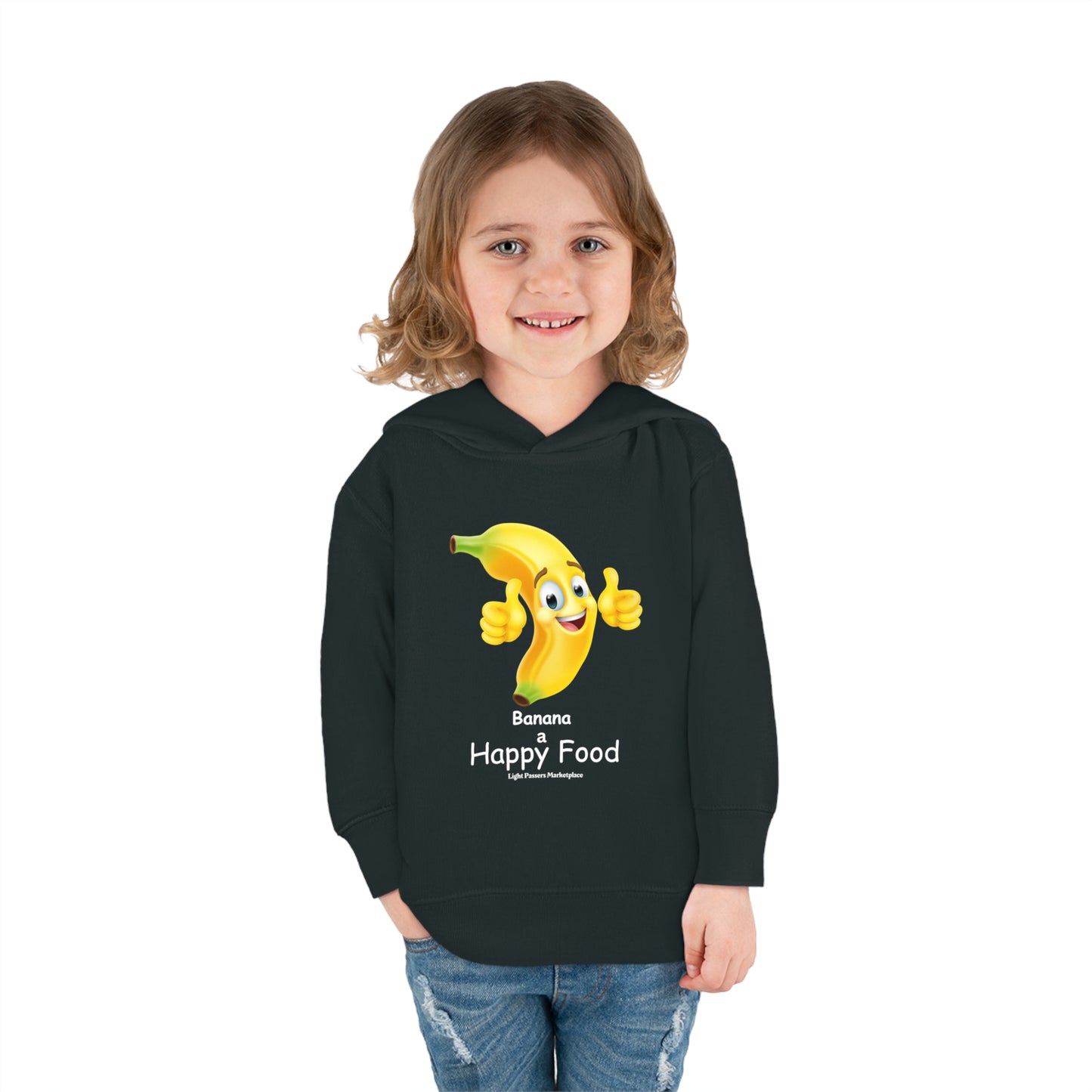 A child in a black Banana Happy Food Toddler Hooded Sweatshirt, smiling at the camera. Features jersey-lined hood, cover-stitched details, side seam pockets for cozy comfort.
