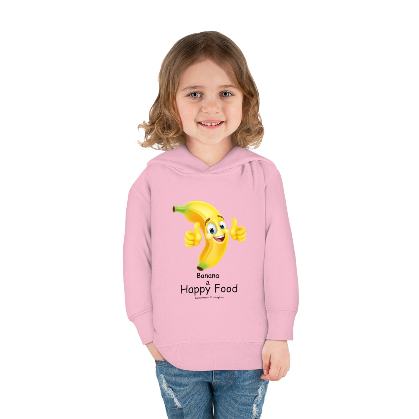 A toddler in a pink hoodie with a cartoon banana and smiling face design, showcasing durable double-needle stitching, side-seam pockets, and a cozy jersey-lined hood.