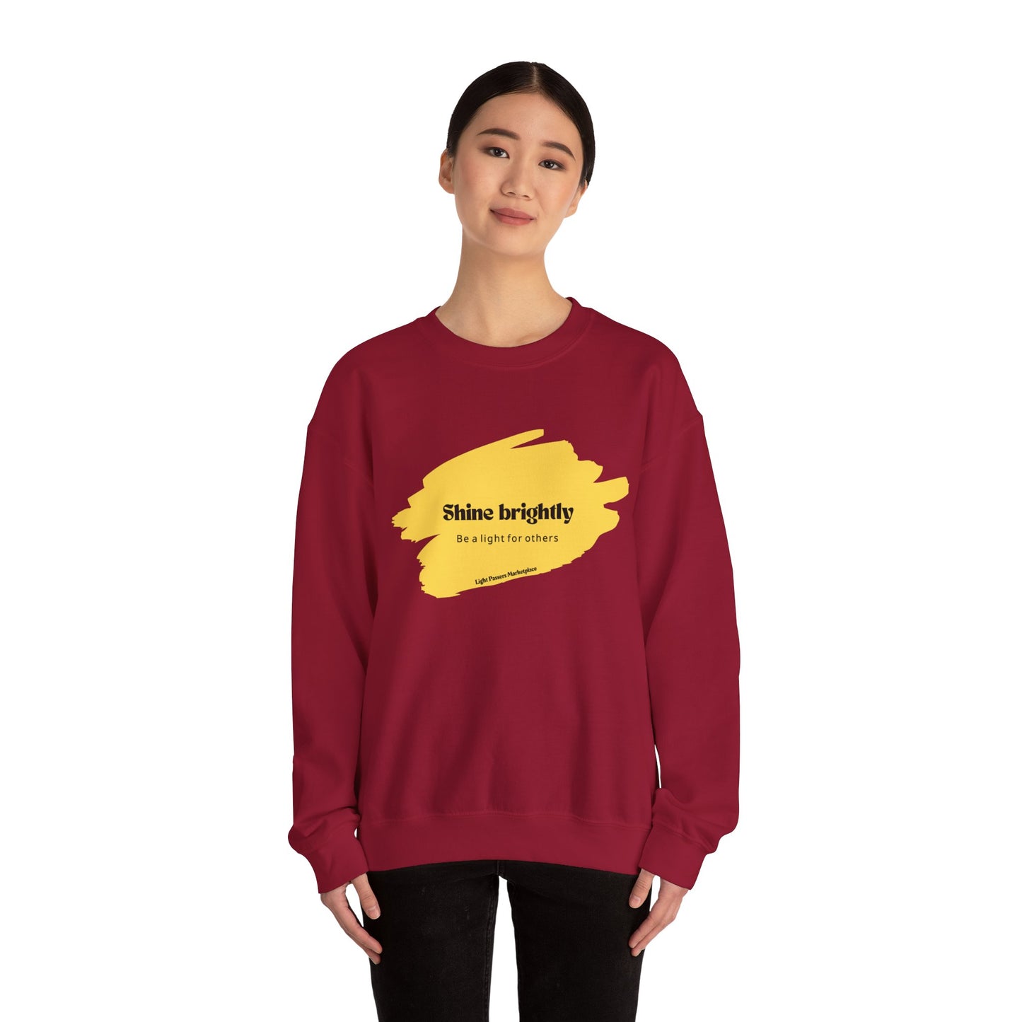 Woman in red crewneck sweatshirt, embodying Shine Brightly and Be the Light for Others, showcasing cozy, ethically-made fabric, perfect for casual wear and spreading positivity.
