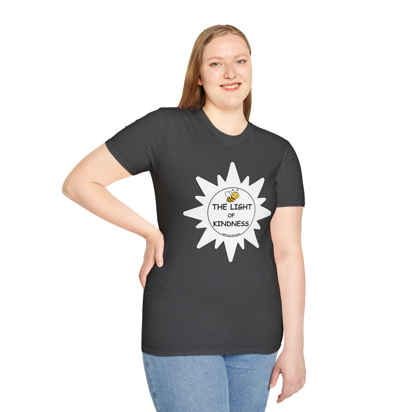 A woman in a black shirt smiles, holding a sign, showcasing a close-up of blue jeans. Product: BEE the Light of Kindness white star Unisex T-shirt.