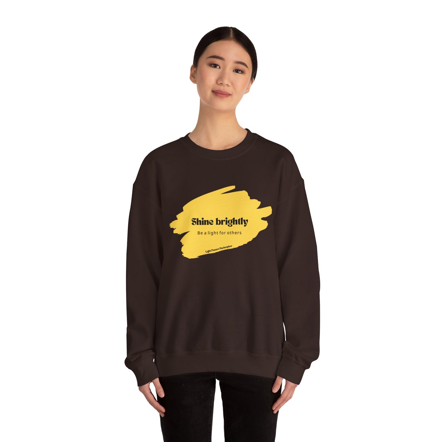 Woman in The Light Inspirational Crewneck Sweatshirt Adult Unisex, featuring a yellow paint stroke and black text, promoting positivity and warmth.