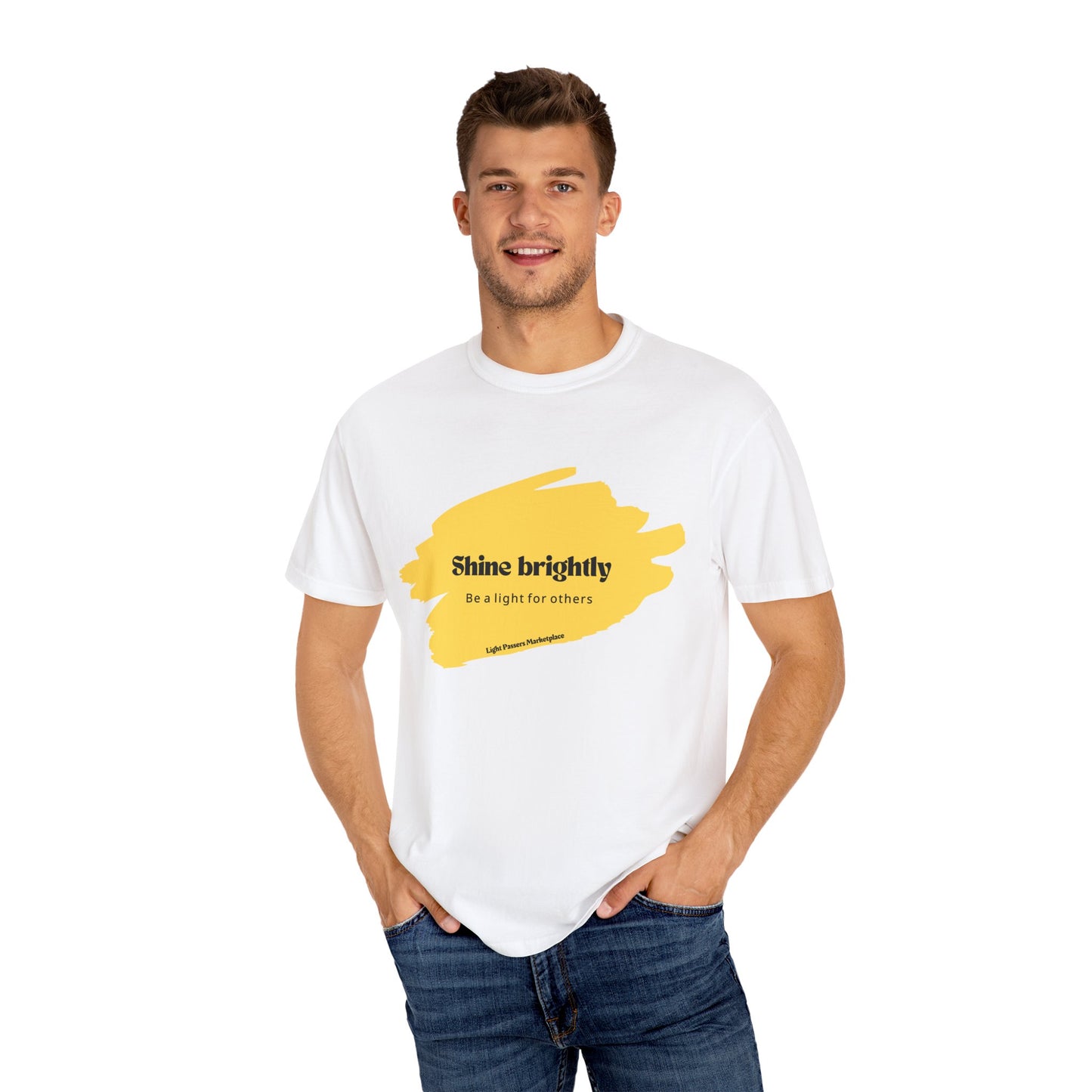 Man wearing a white Shine Brightly for Others T-shirt, hands in pockets, showcasing its relaxed fit and casual style.