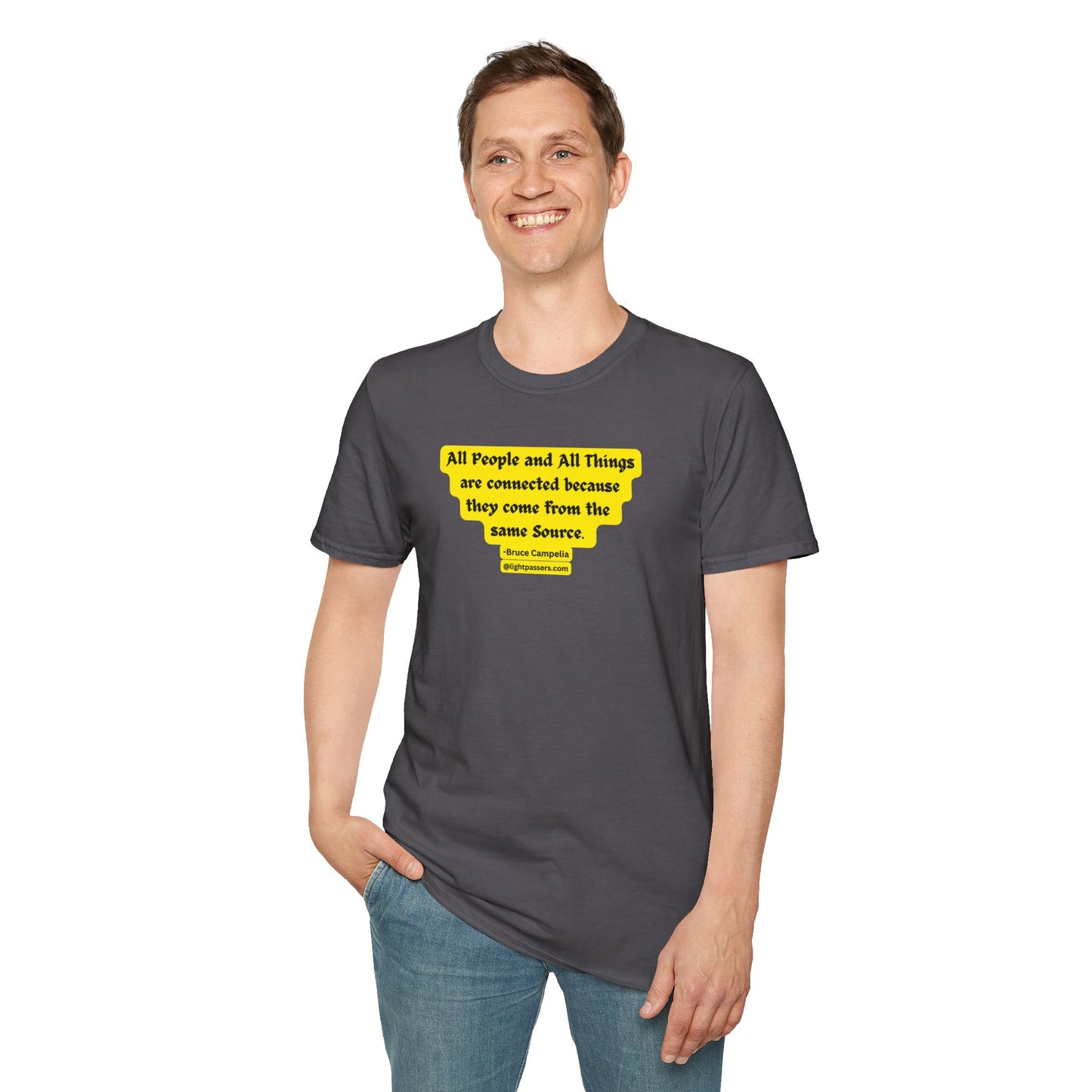 A smiling man in a grey shirt with a yellow sticker, hands in pockets. Unisex heavy cotton tee, foundational casual wear with premium printing surface, no side seams, and shoulder tape for durability.