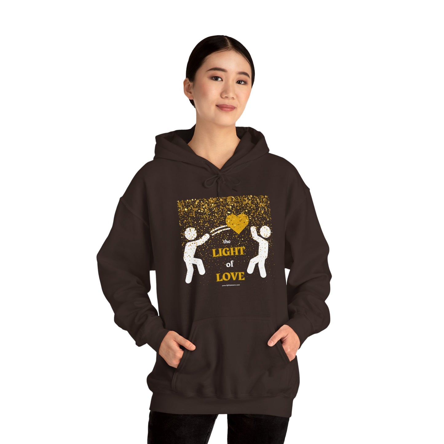 A person in a black hoodie with a yellow heart design, featuring a kangaroo pocket and drawstring hood. Made of 50% cotton and 50% polyester for warmth and comfort.
