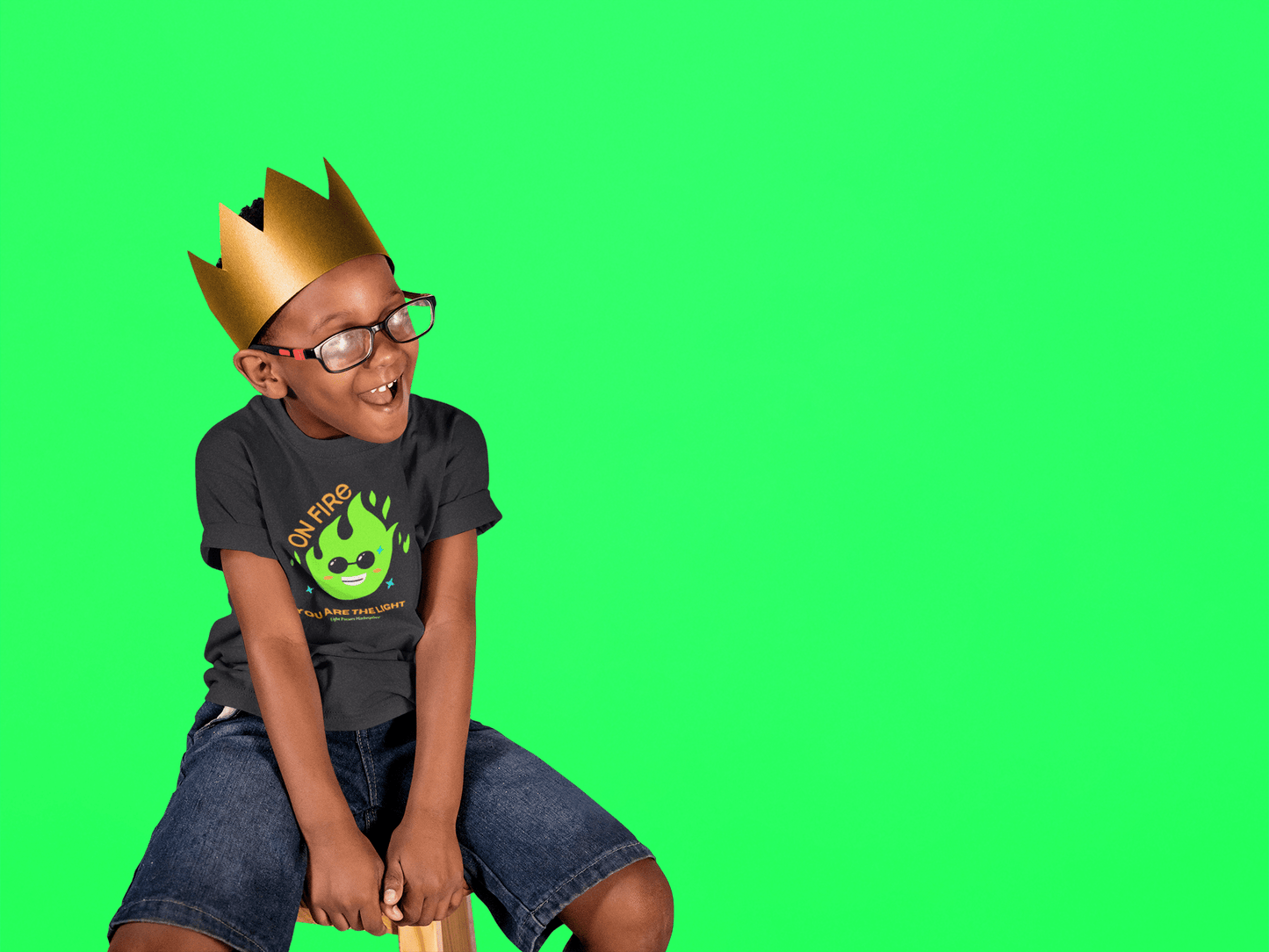 Boy wearing a crown and glasses, dressed in The Light Love and Peace ON FIRE toddler t-shirt, highlighting its soft, durable fabric ideal for sensitive skin.