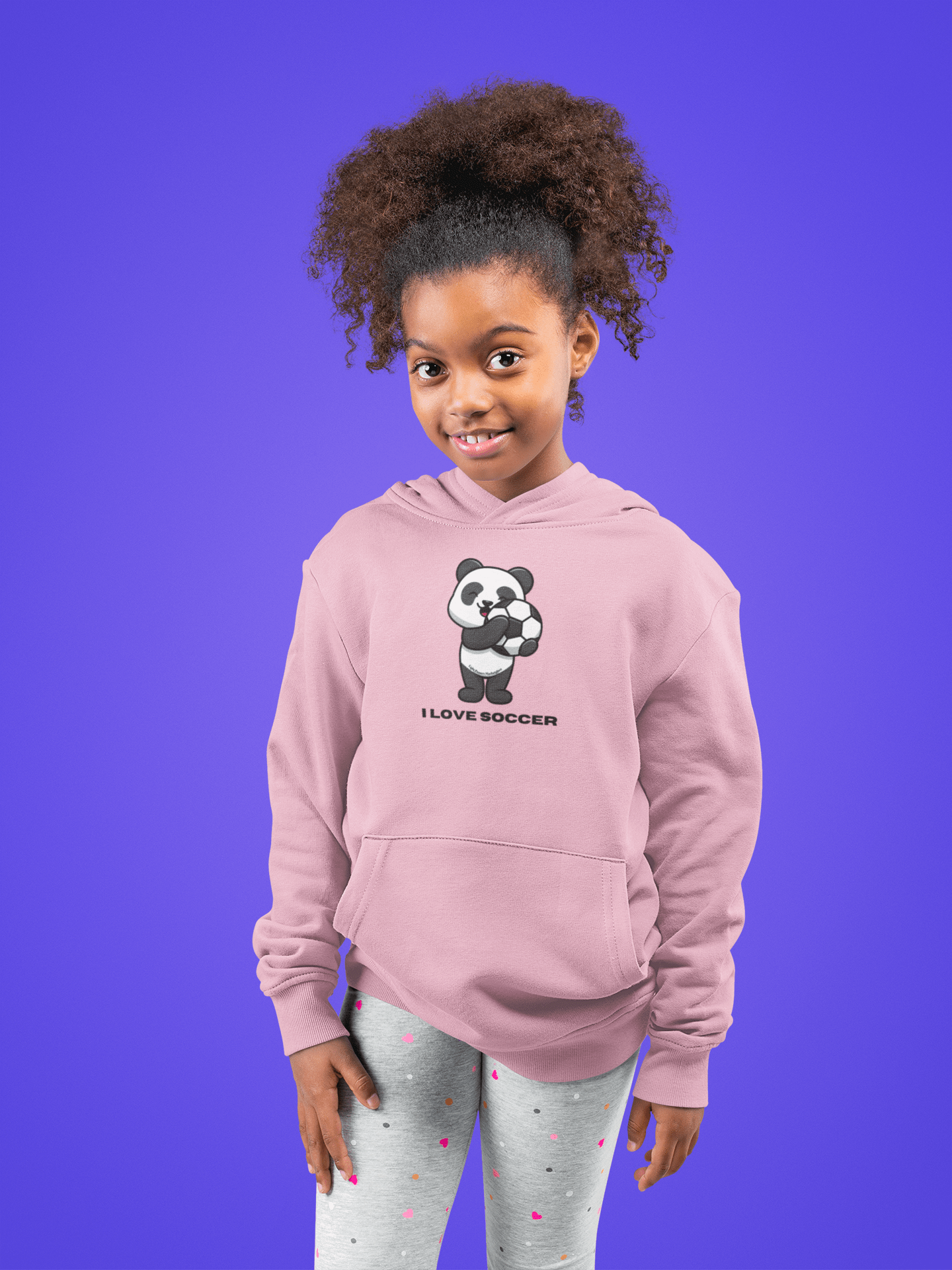 A girl in a pink panda sweatshirt with a cartoon panda holding a football. Youth blend hooded sweatshirt, 50% cotton 50% polyester, kangaroo pocket, twill taping.