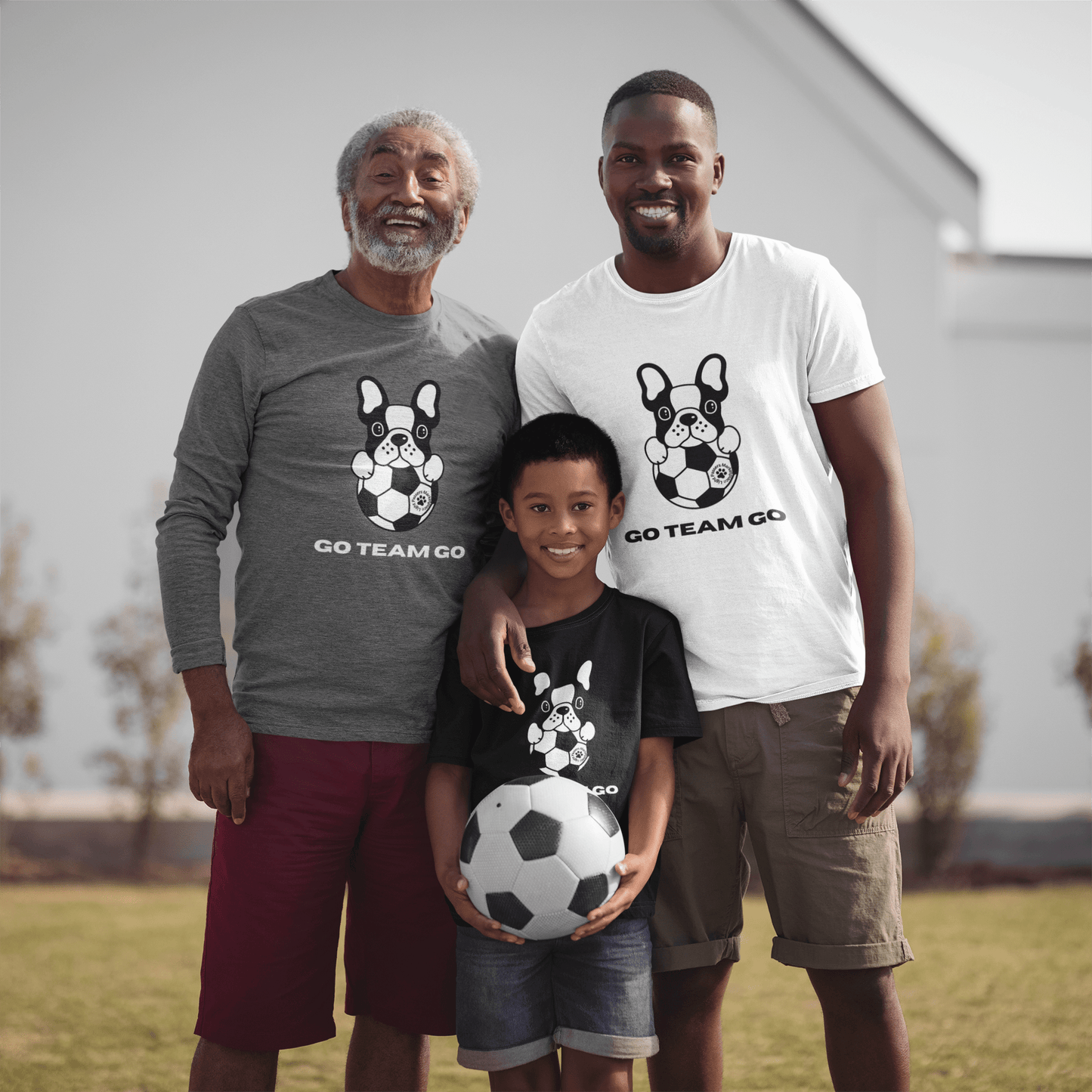 Men and a boy pose with a football and dog, wearing Teams Soccer Dog Adult Unisex Garment-dyed Long Sleeve shirts, showcasing comfort and style.