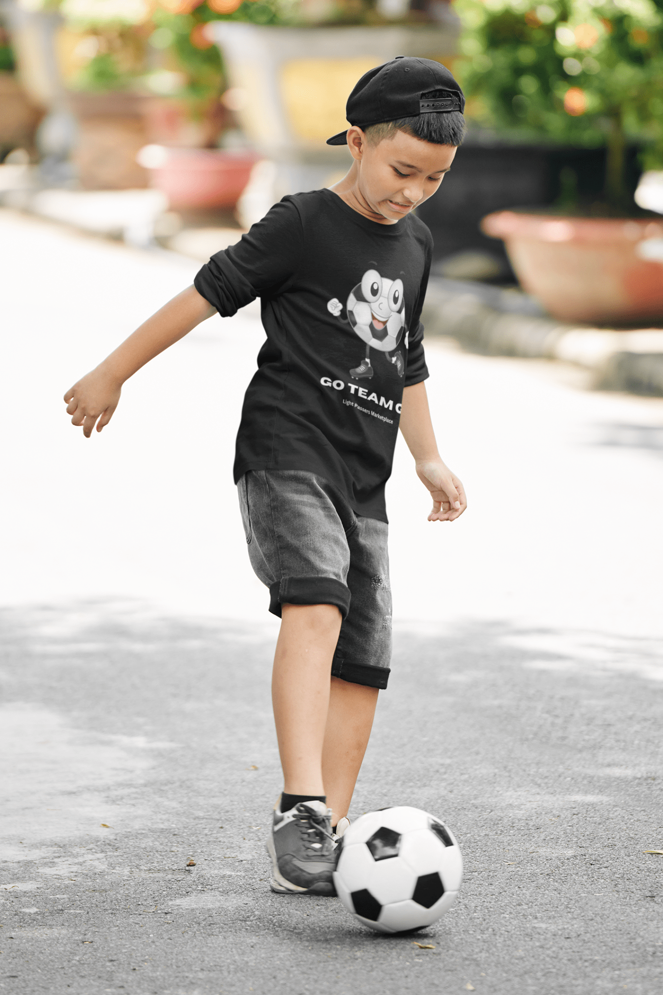 Teams Youth Long Sleeve Soccer Ball Guy shirt featuring a cartoon soccer ball design, perfect for young sports fans, emphasizing a fun and energetic vibe.