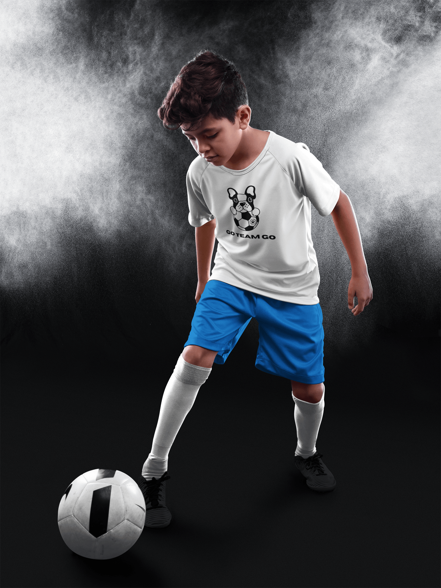 Boy in Soccer Dog Go Team Go Youth T-shirt, wearing blue shorts, holding a soccer ball, showcasing team spirit and love for soccer.