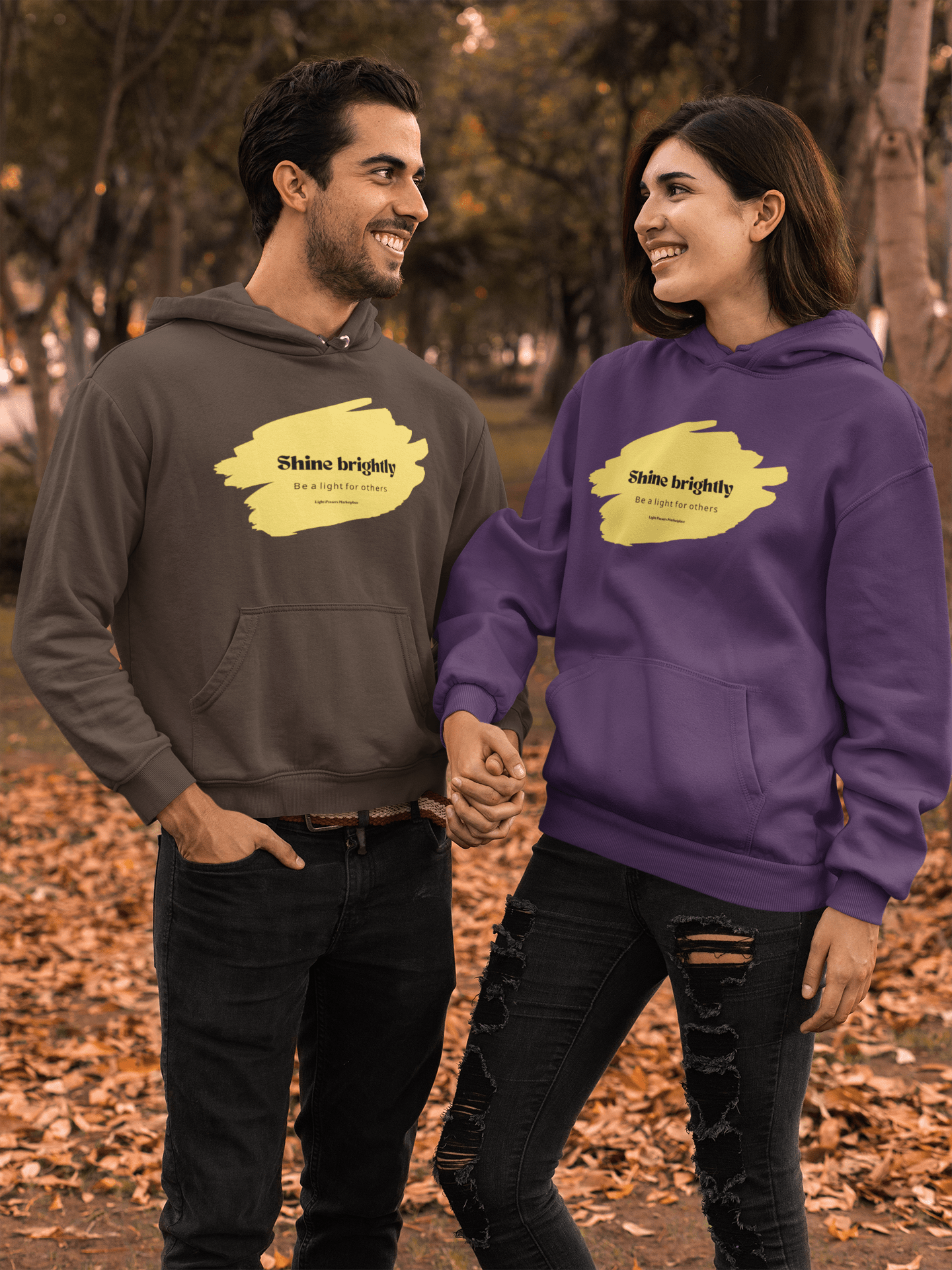 The Light Inspirational Hoodie - Shine Brightly Adult Unisex Heavy Blend™ Sweatshirt, worn by a couple holding hands, featuring a cozy design with a spacious pouch pocket.