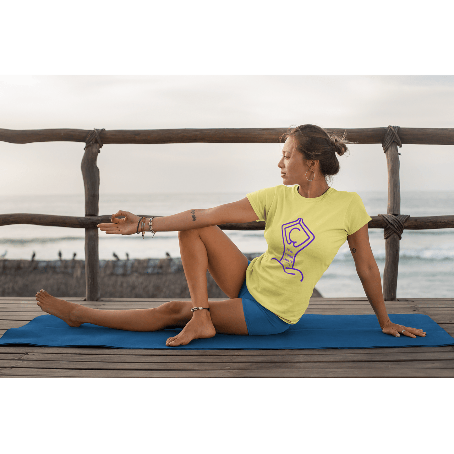Woman practicing yoga on a deck, wearing the Health The Light Yoga Find Your Light Adult Unisex T-shirt, embodying serenity and mindfulness.