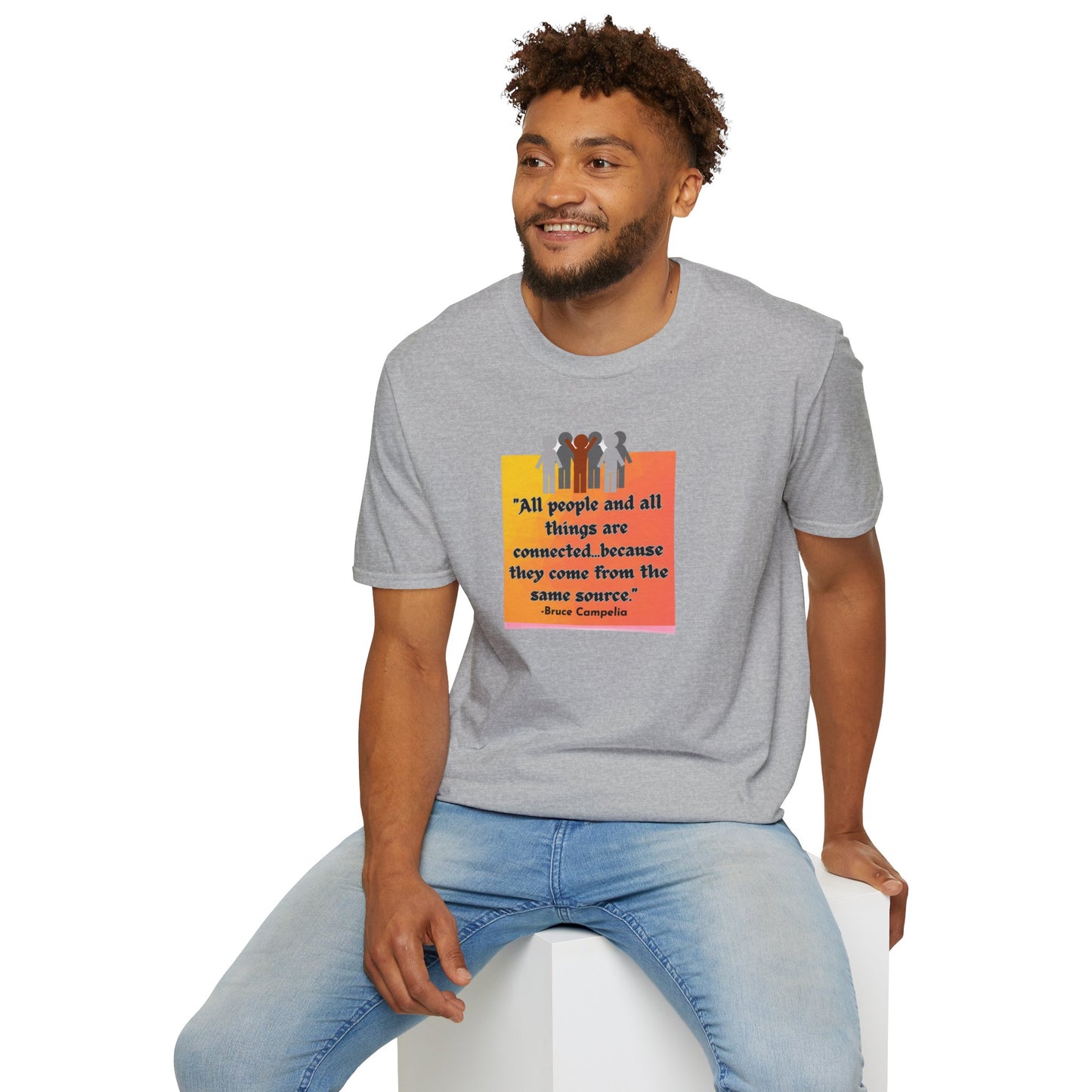 A man in a grey shirt sits on a cube, showcasing the All People are Connected orange plaque Unisex T-shirt. The image features a group of people on a poster, emphasizing the tee's classic fit and 100% cotton fabric.