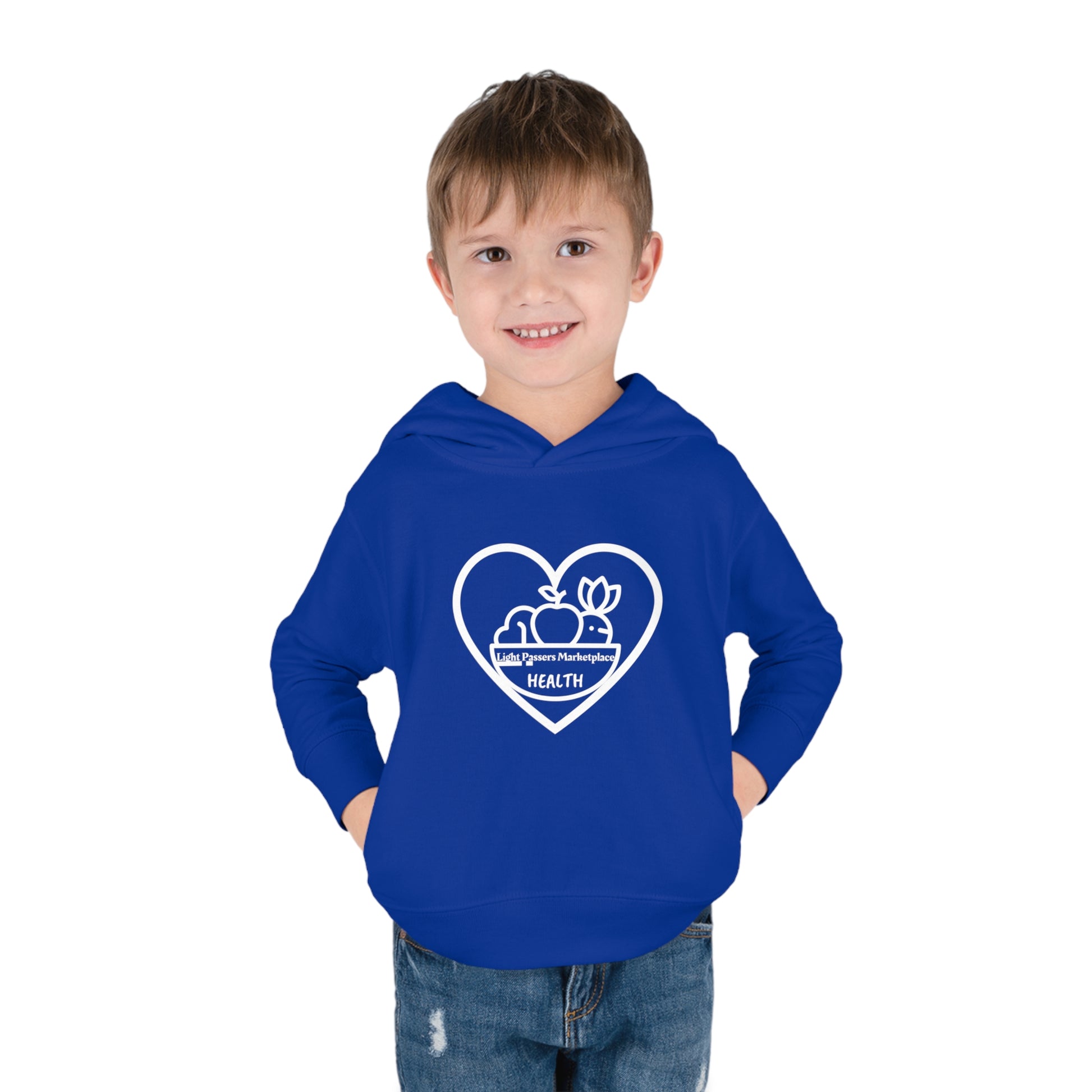 A toddler in a blue sweatshirt with a heart logo, showcasing side seam pockets and cover-stitched details for durability and comfort. Fruit Basket Toddler Hoodie in 60% cotton, 40% polyester blend.
