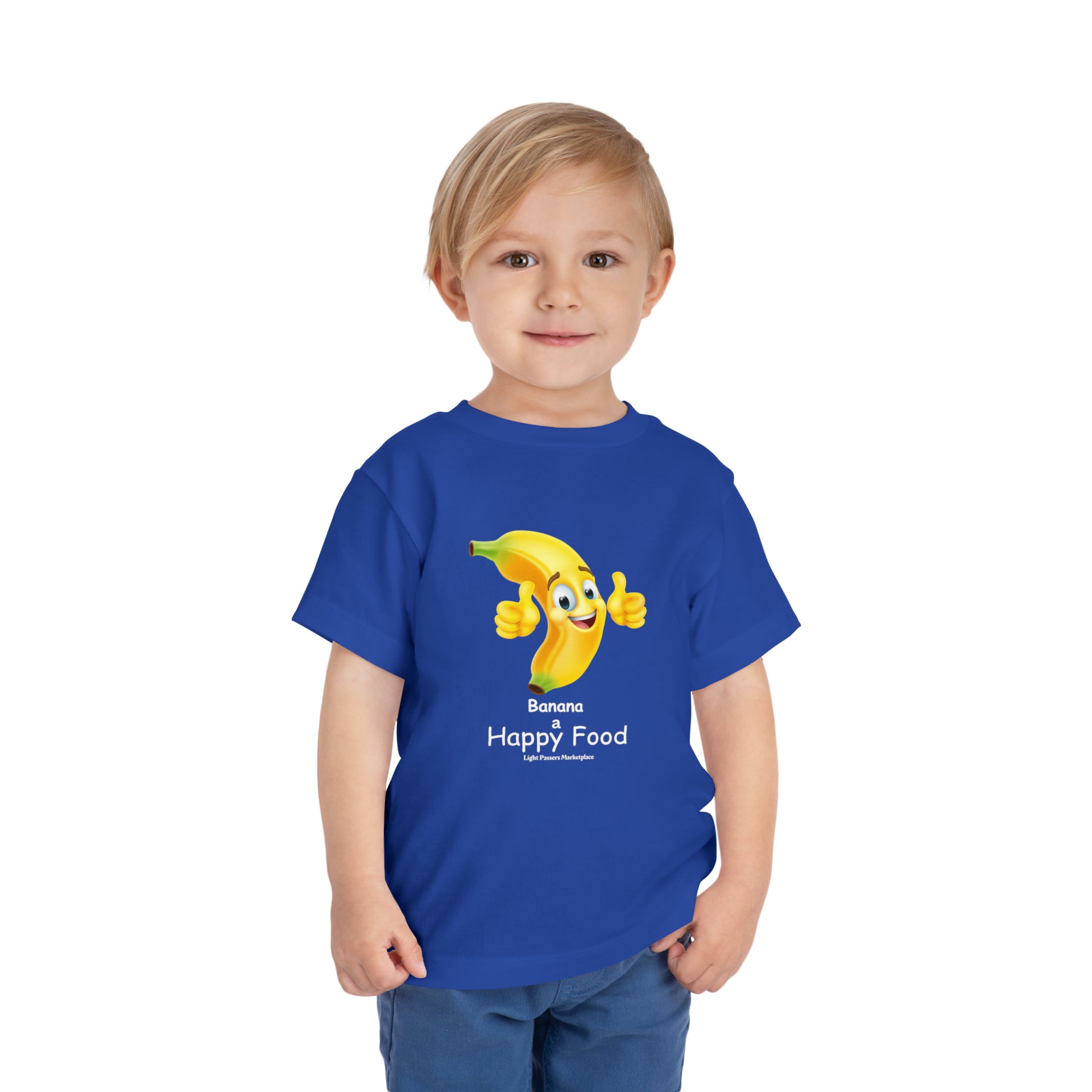 A happy toddler wears a blue shirt with a cartoon banana giving a thumbs up. Bella Canvas tee, 100% cotton, tear-away label for comfort.