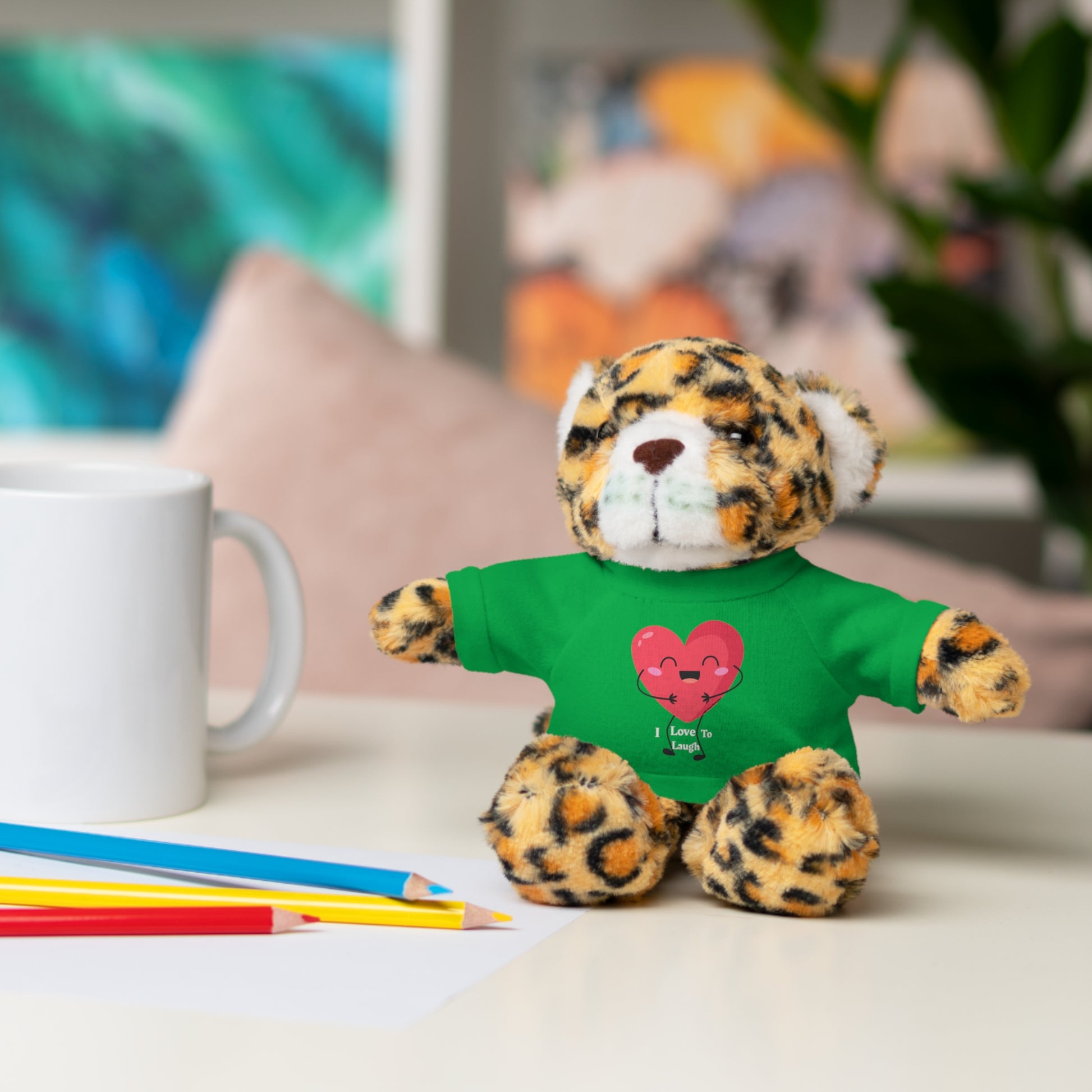 Cool Stuff Stuffies Choice of 6 Animals features a stuffed animal in a green shirt, seated on a table, with a heart on its removable t-shirt.
